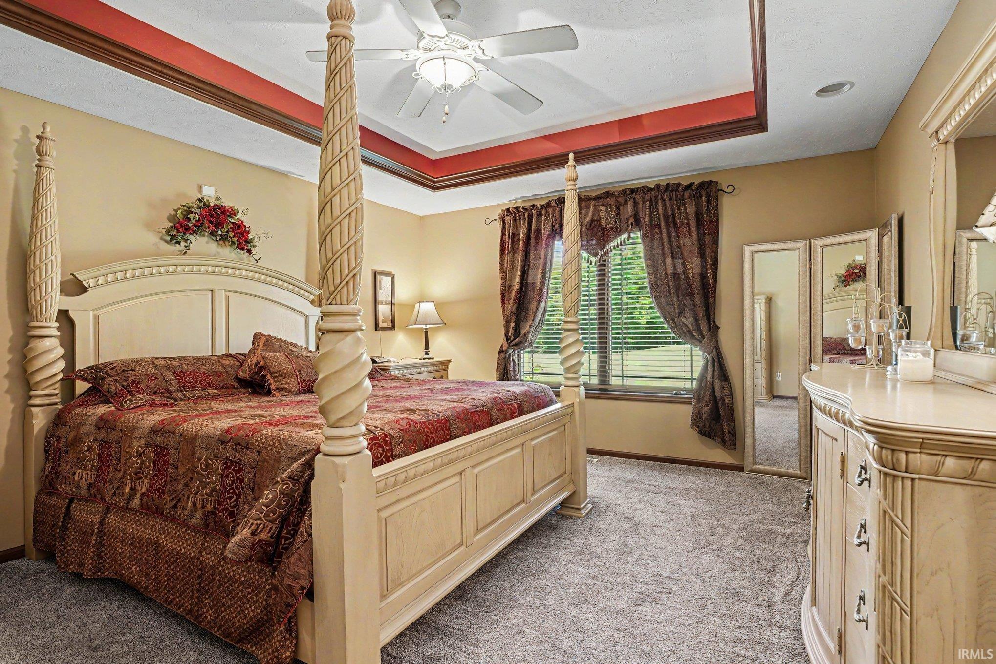 Recessed ceiling with red accent trim, ceiling fan, carpeted flooring, and a large window with horizontal blinds