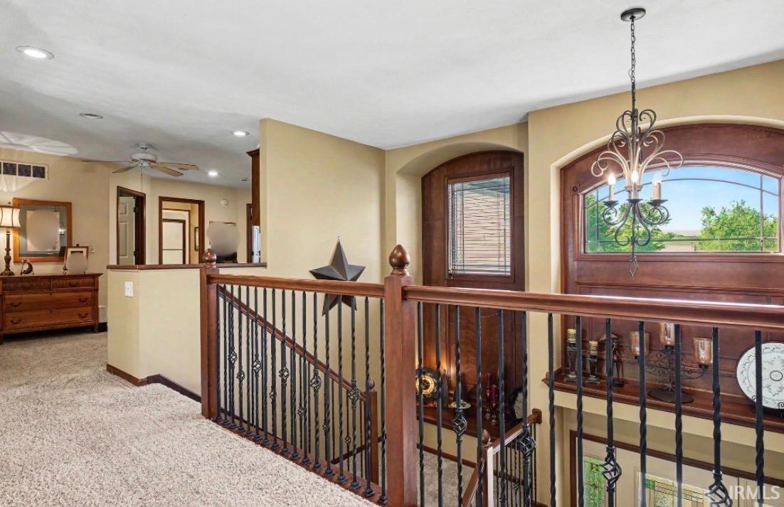 Arched wooden door with an integrated transom window and a wrought iron chandelier