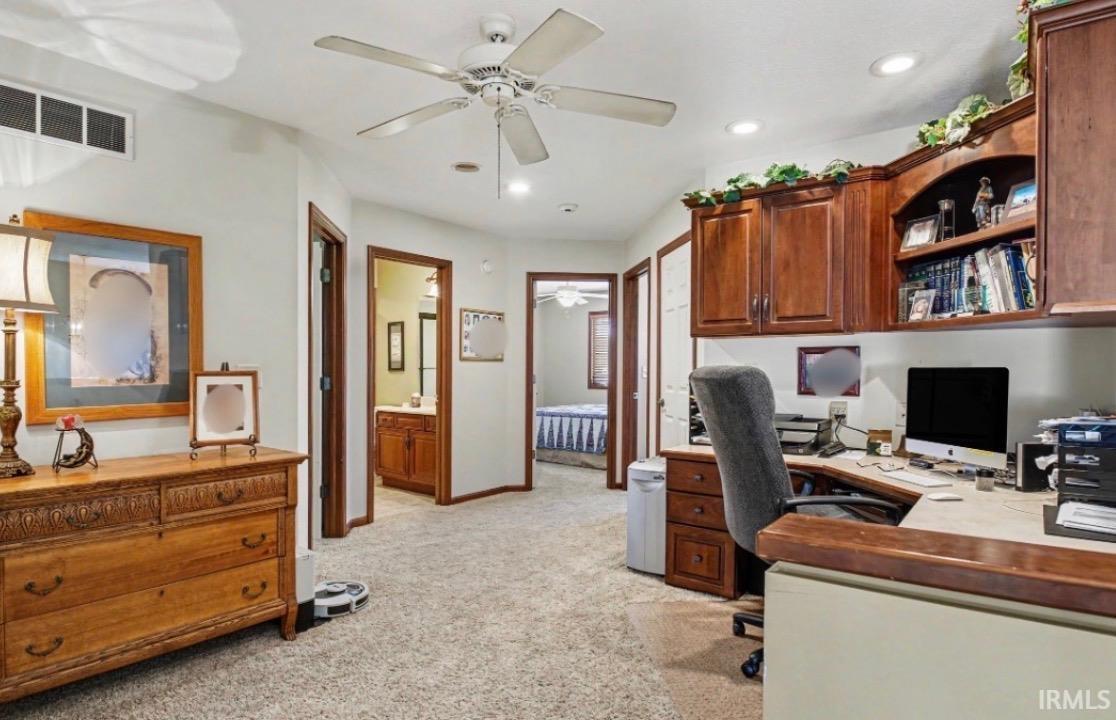 Dedicated office space featuring built-in wood cabinetry, integrated shelving, and recessed lighting
