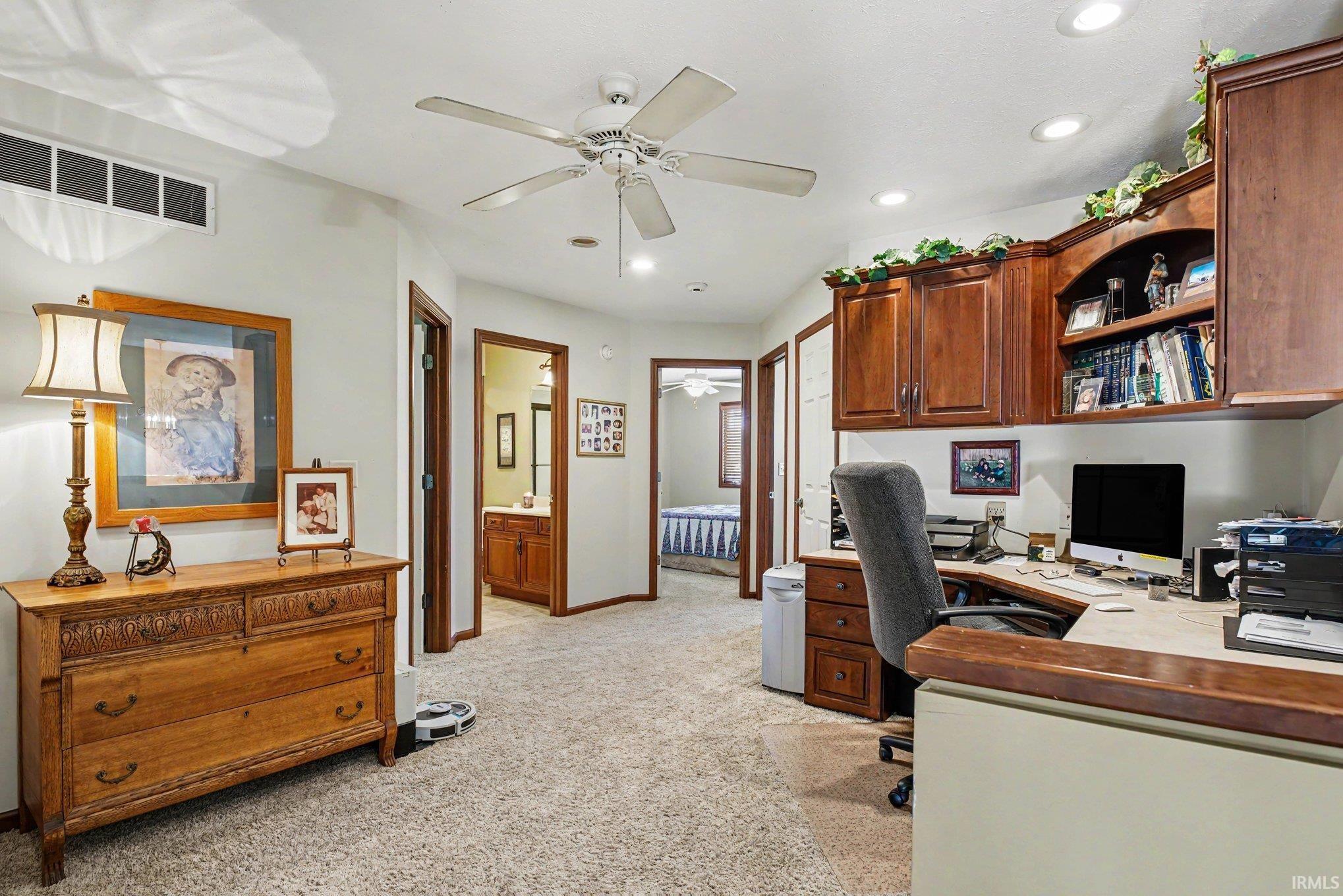 Dedicated home office space featuring built-in wood cabinetry, integrated shelving, and a coordinating wood-finish countertop