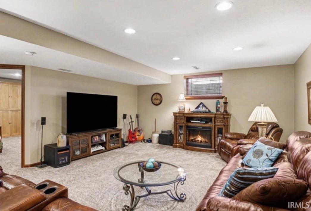 Spacious finished room featuring recessed lighting and a corner fireplace