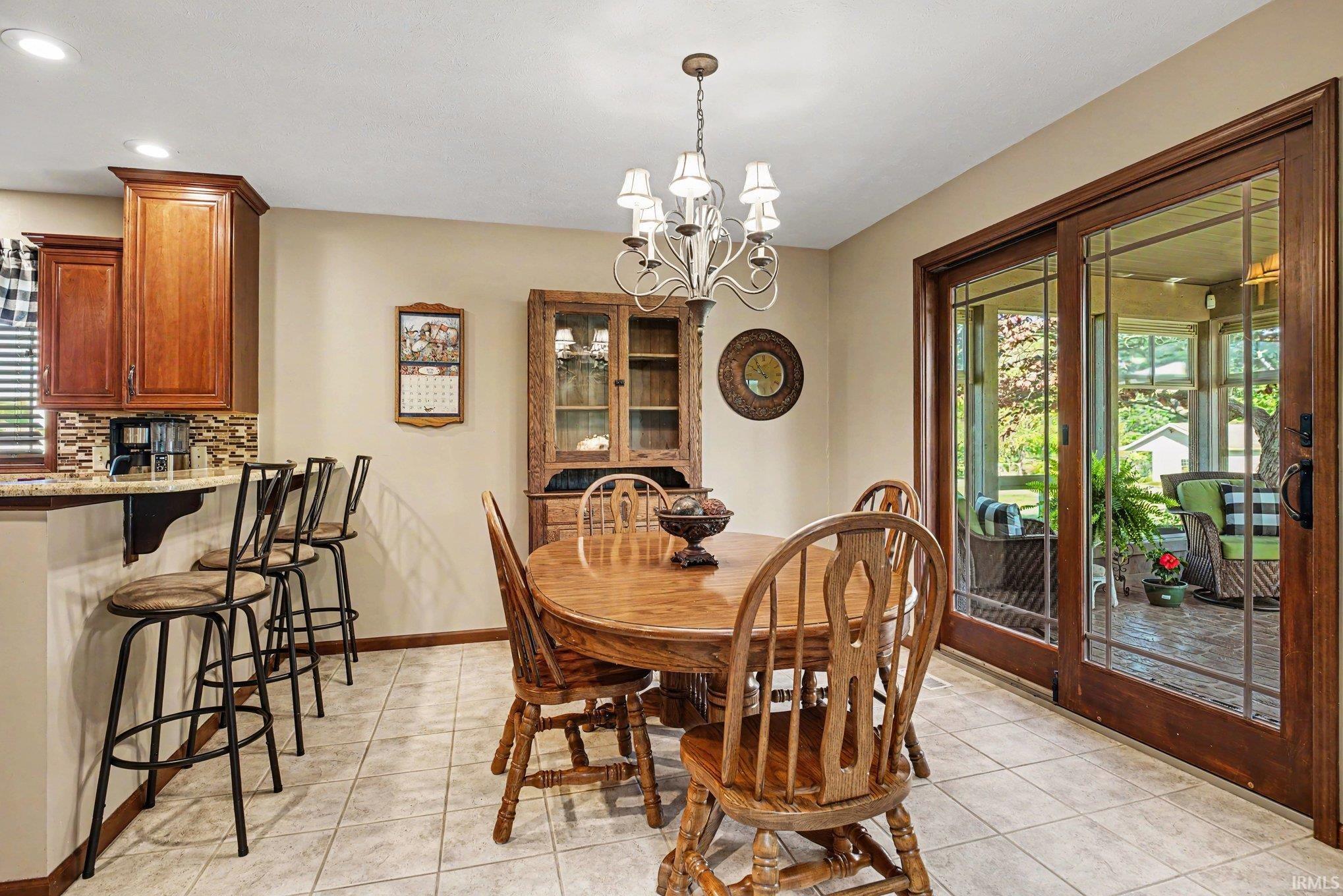 Dining area featuring a chandelier, tile flooring, and sliding glass doors
