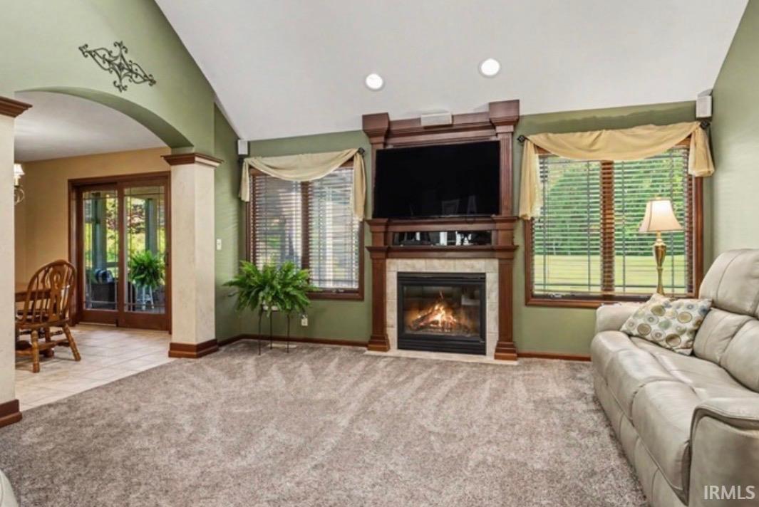 Living area featuring a gas fireplace with a stone surround, a wood mantel, and integrated media cabinetry