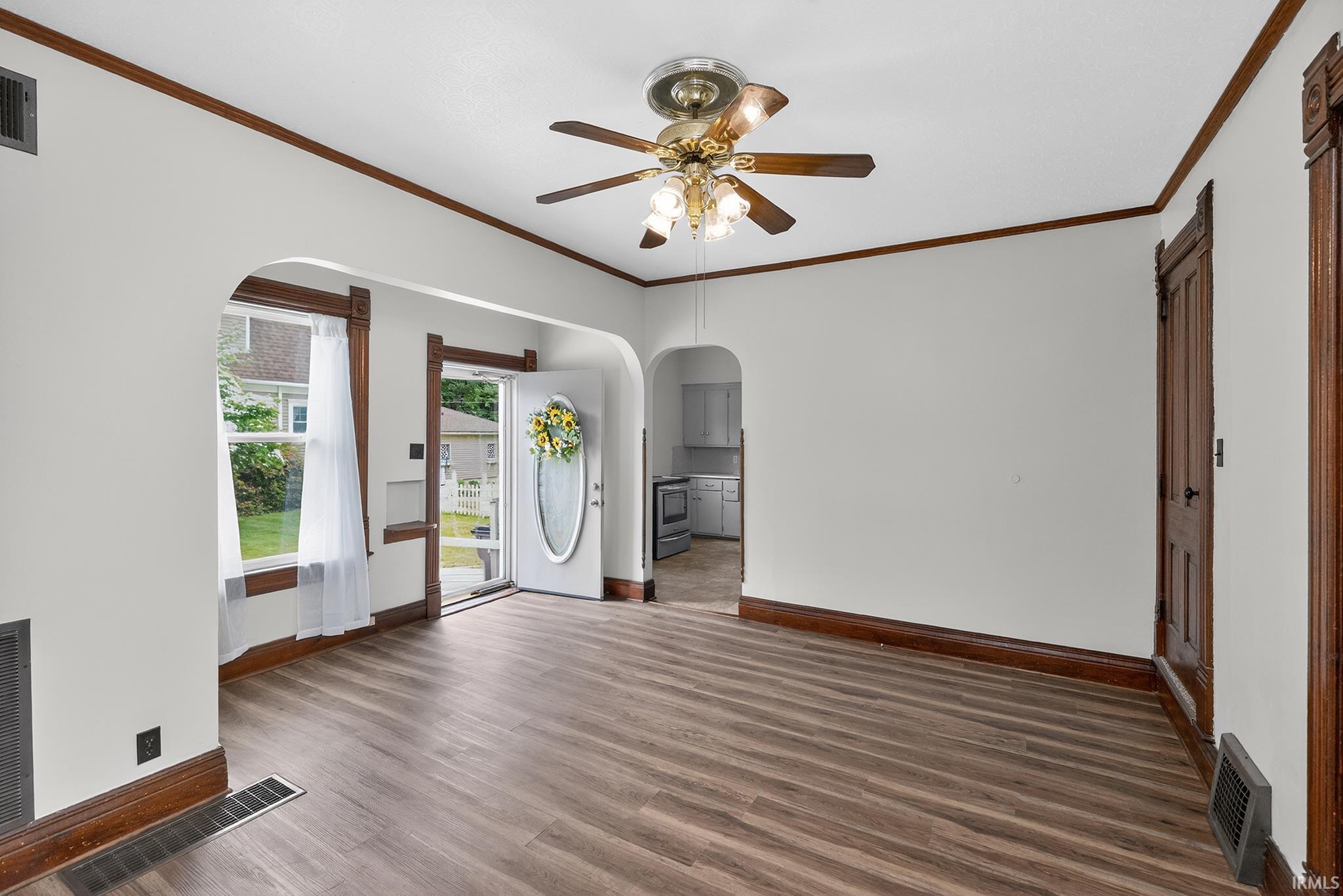Spacious interior featuring wood-finish flooring, white walls, and dark wood trim