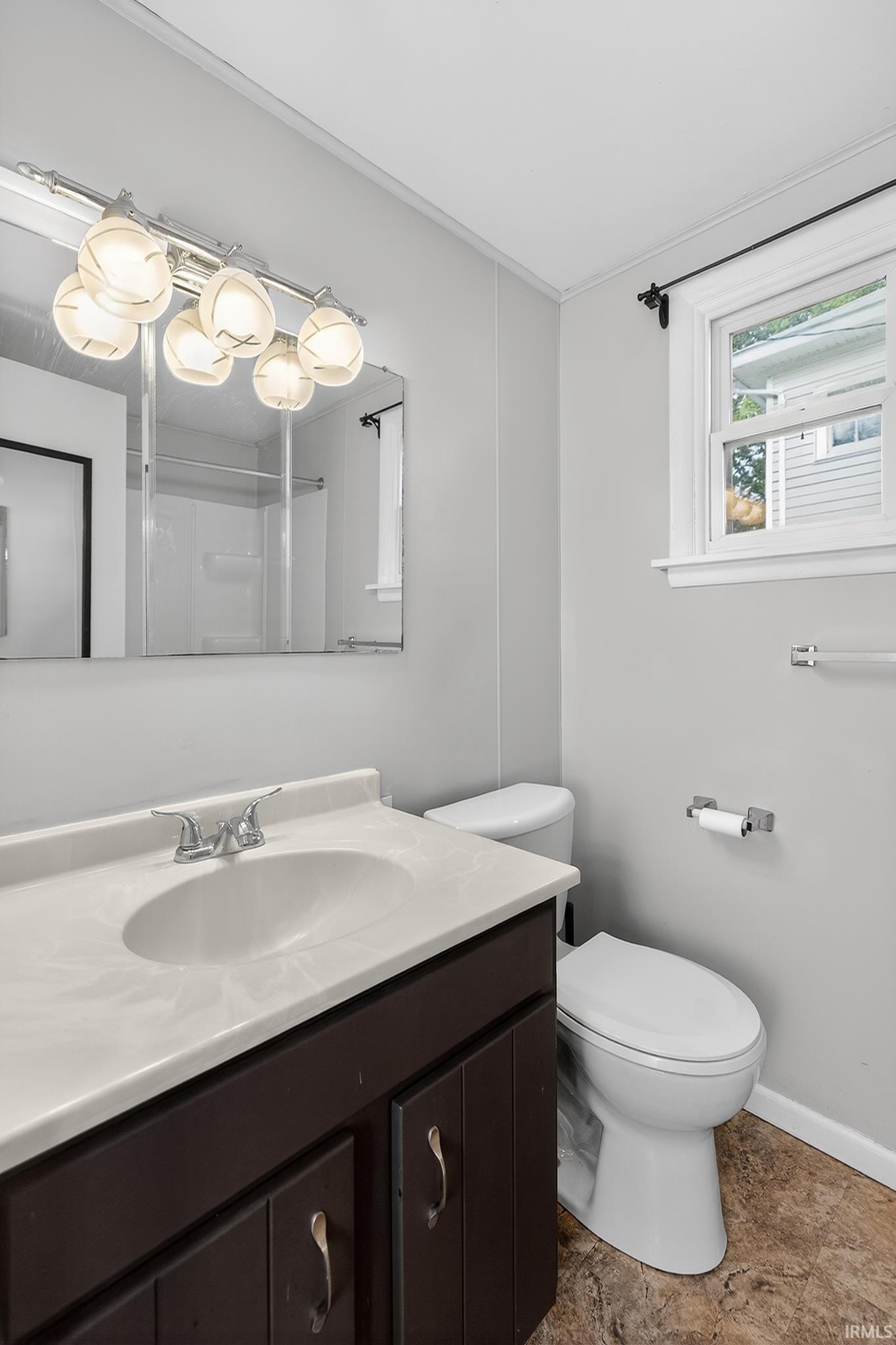 Bathroom vanity with an integrated sink, polished chrome faucet, and dark wood-finish cabinetry