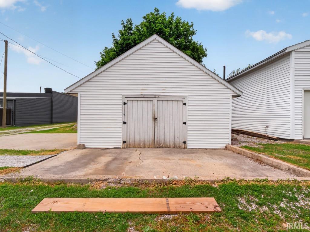 Detached garage with horizontal siding and a gable roof