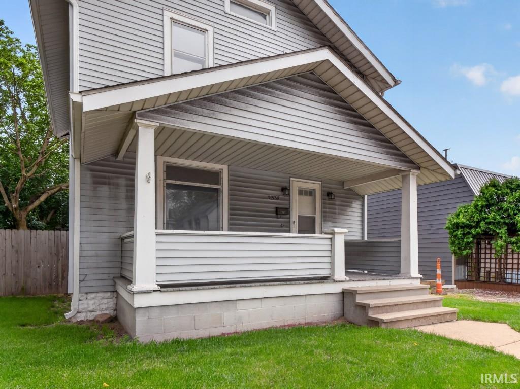 Light gray siding exterior with a covered porch featuring white columns