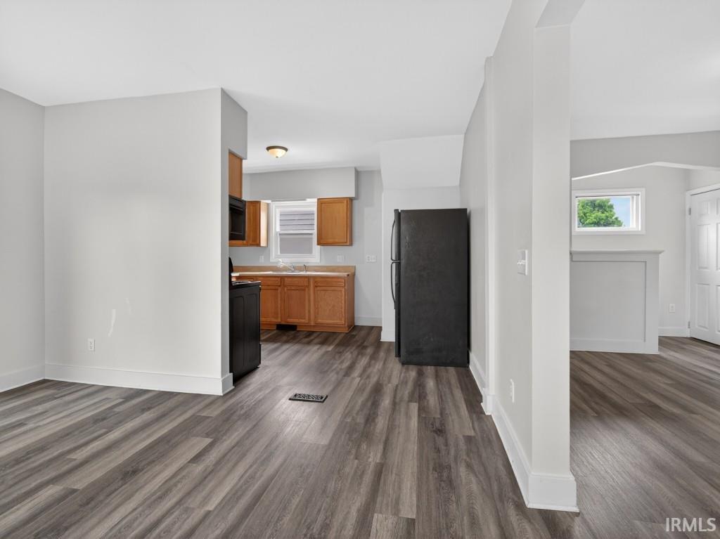 Open concept living area featuring wood-finish flooring, light grey walls, and white trim