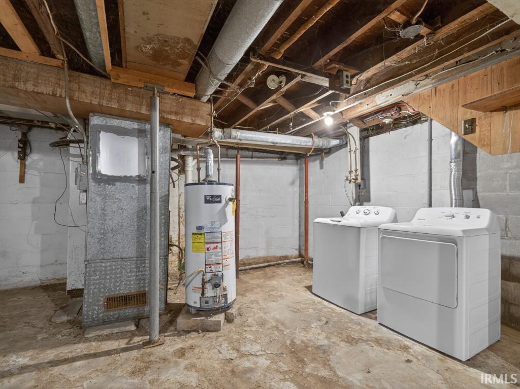 Basement utility area featuring exposed joists, concrete block walls, and a concrete floor