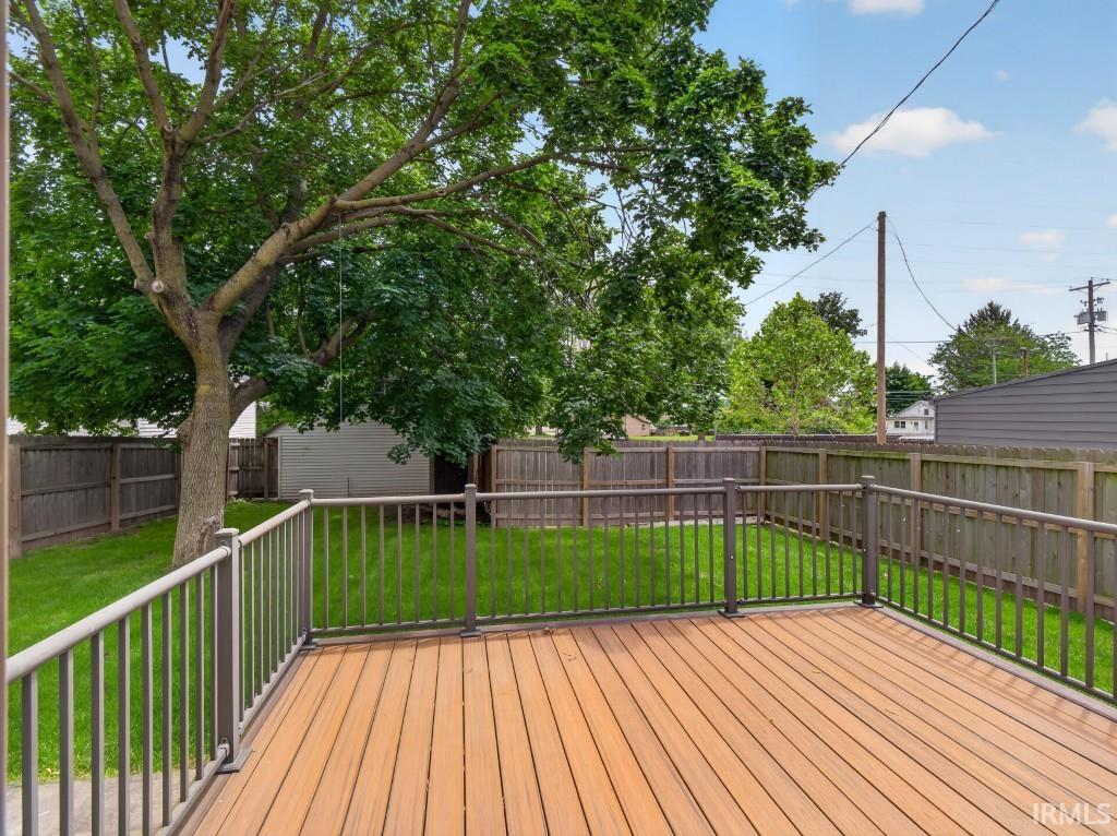 Expansive outdoor deck featuring wood-finish flooring and metal railings