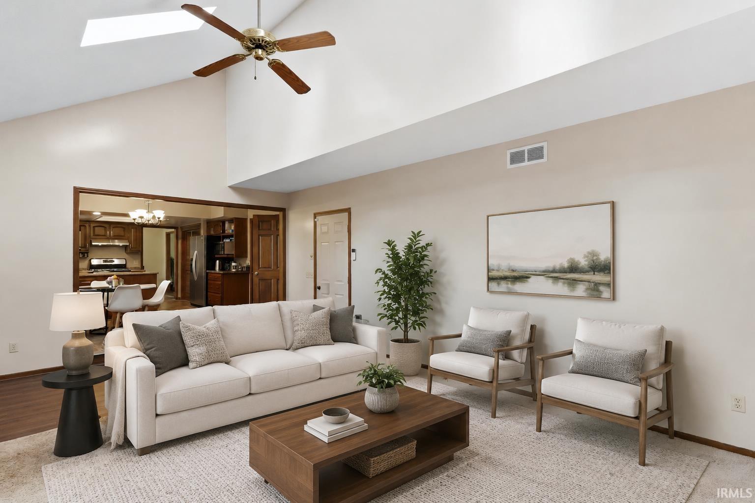Vaulted ceiling with skylight, ceiling fan, wood-finish flooring, and recessed framed opening