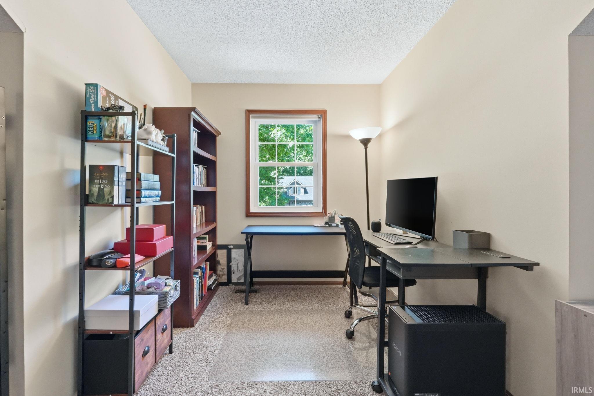 Dedicated space featuring a single window with wood-trim framing, neutral painted walls, and textured flooring