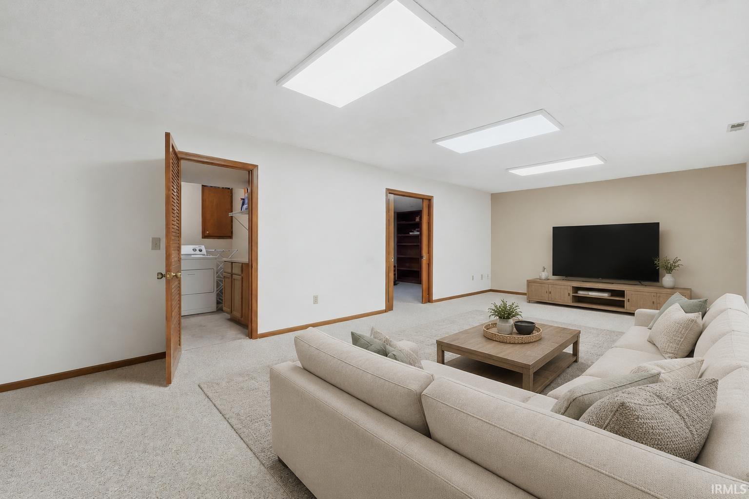 Recessed panel lighting, carpeted flooring, wood-finish doors, and a laundry area with built-in cabinetry