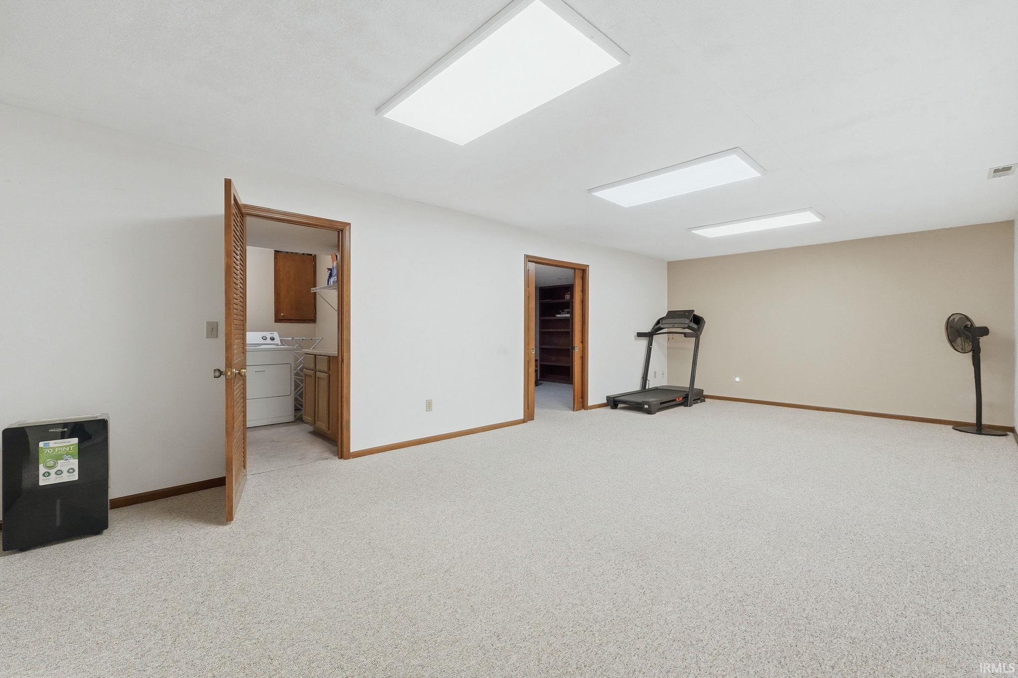 Carpeted recreation room with recessed lighting and neutral wall tones