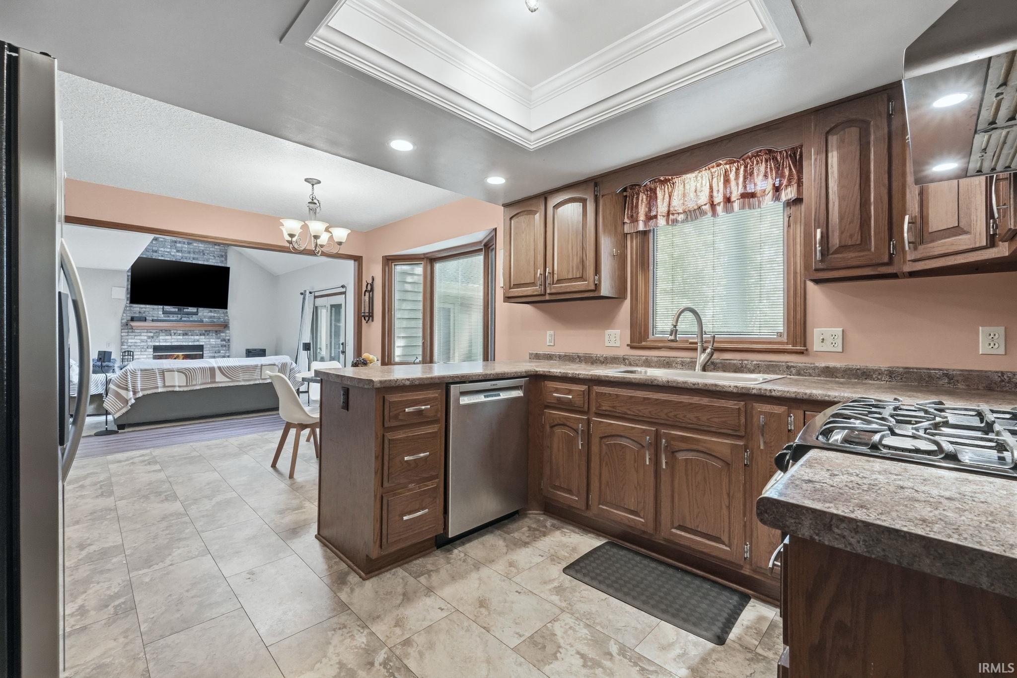 Kitchen featuring wood-finish cabinetry, stainless steel dishwasher, and a four-burner gas range