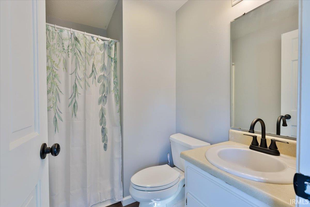 Bathroom featuring a white vanity with an integrated sink, a dark bronze faucet, and a wall-mounted mirror