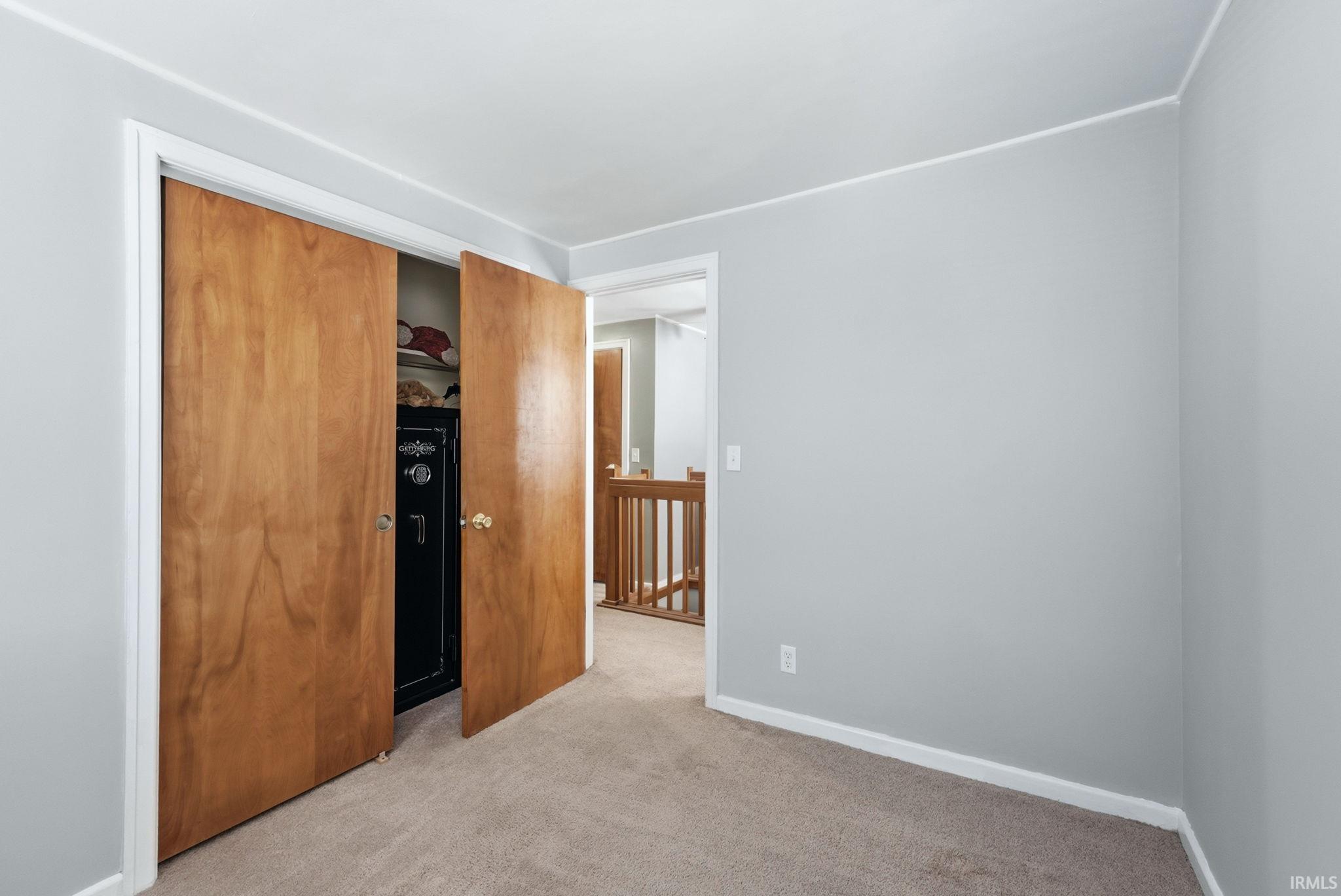 Room featuring light gray walls and beige carpet flooring