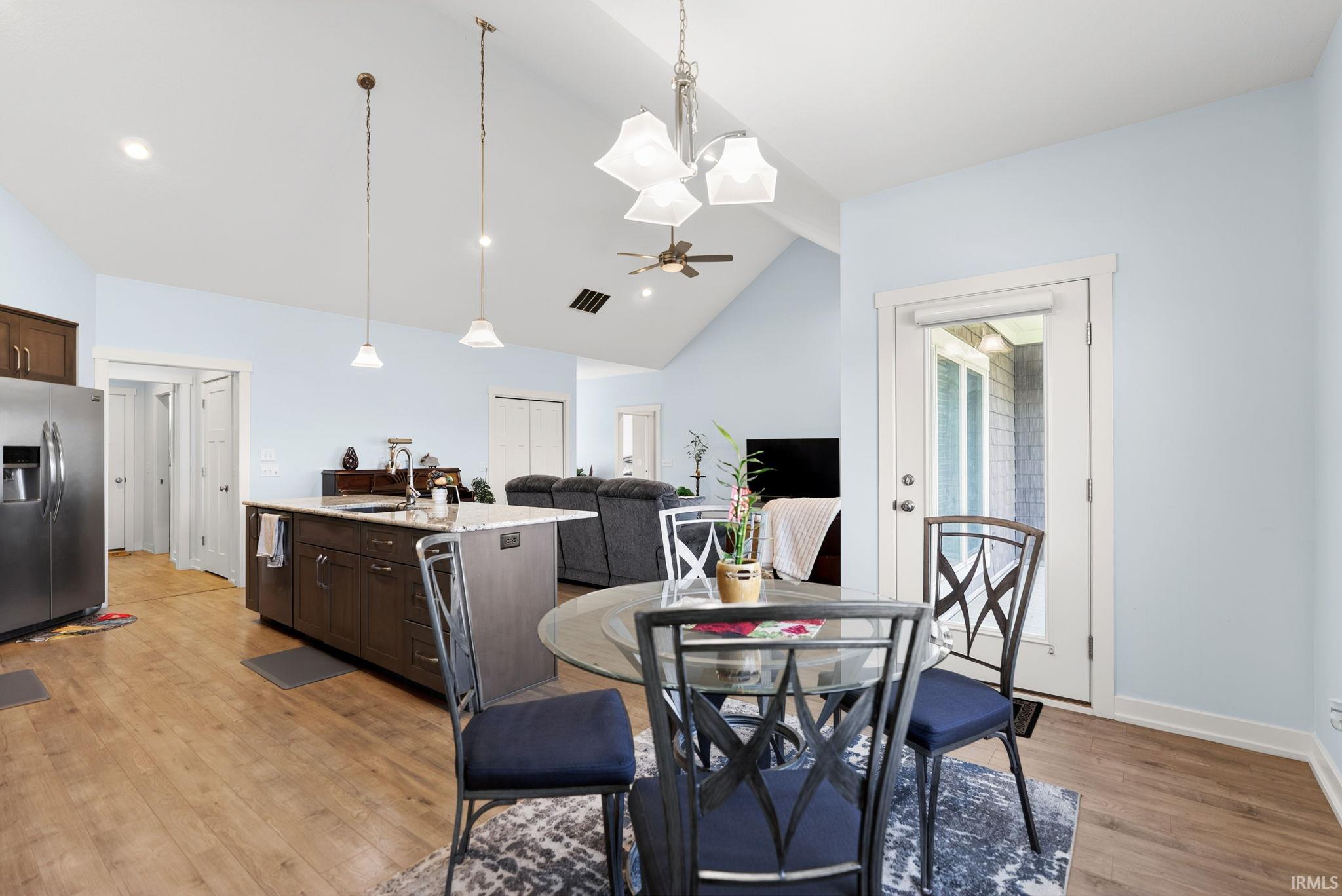 Open-concept interior featuring light wood-finish flooring and vaulted ceilings