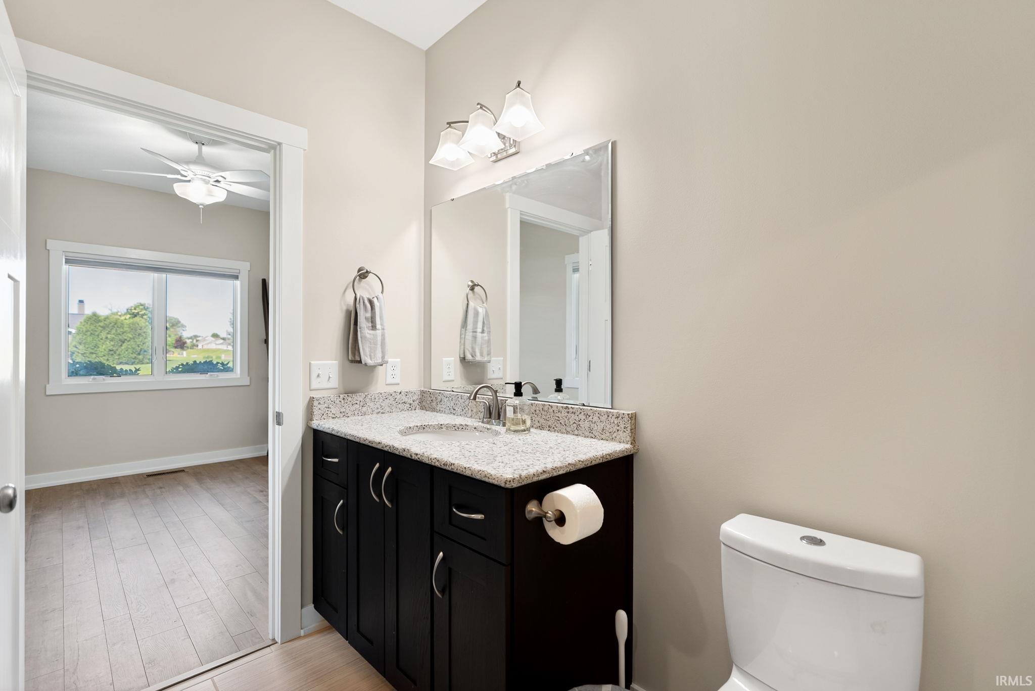 Bathroom vanity featuring a speckled countertop, undermount sink, and dark wood-finish cabinetry
