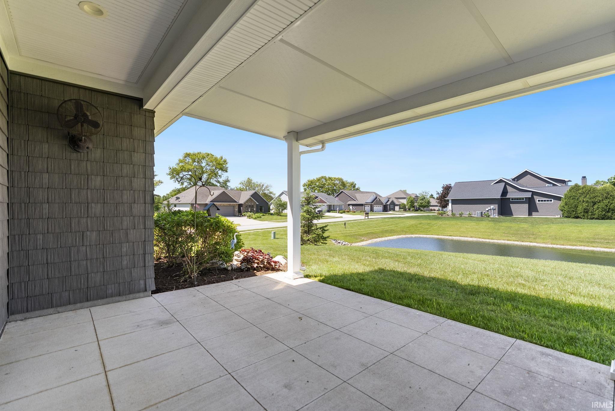 Covered concrete patio featuring shingle siding and recessed lighting
