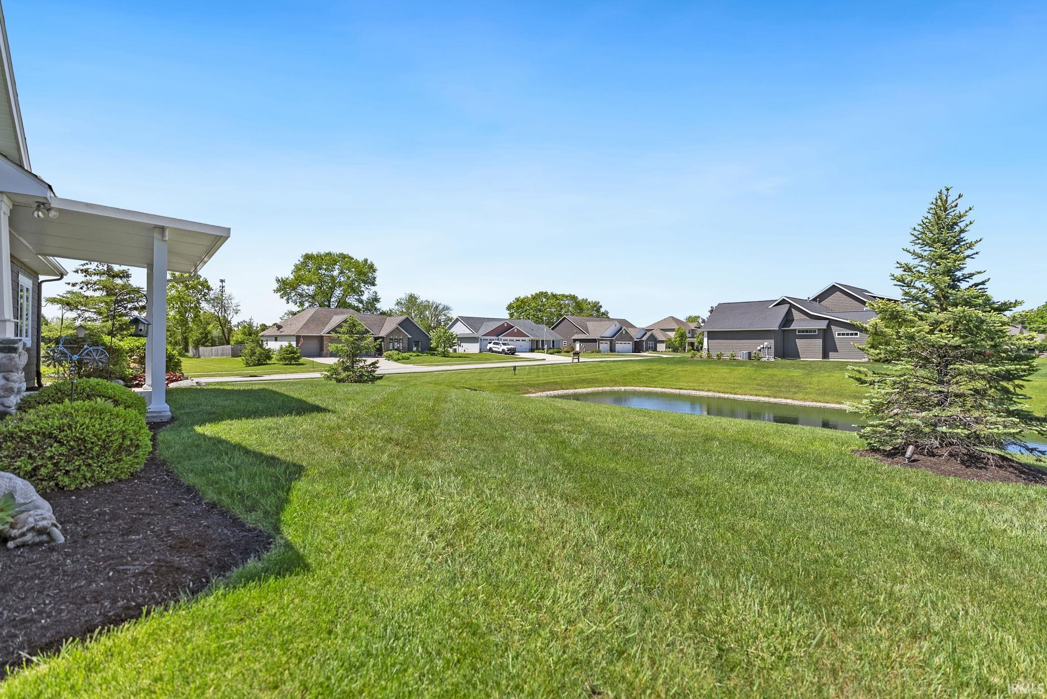 Expansive green lawn with a serene pond feature