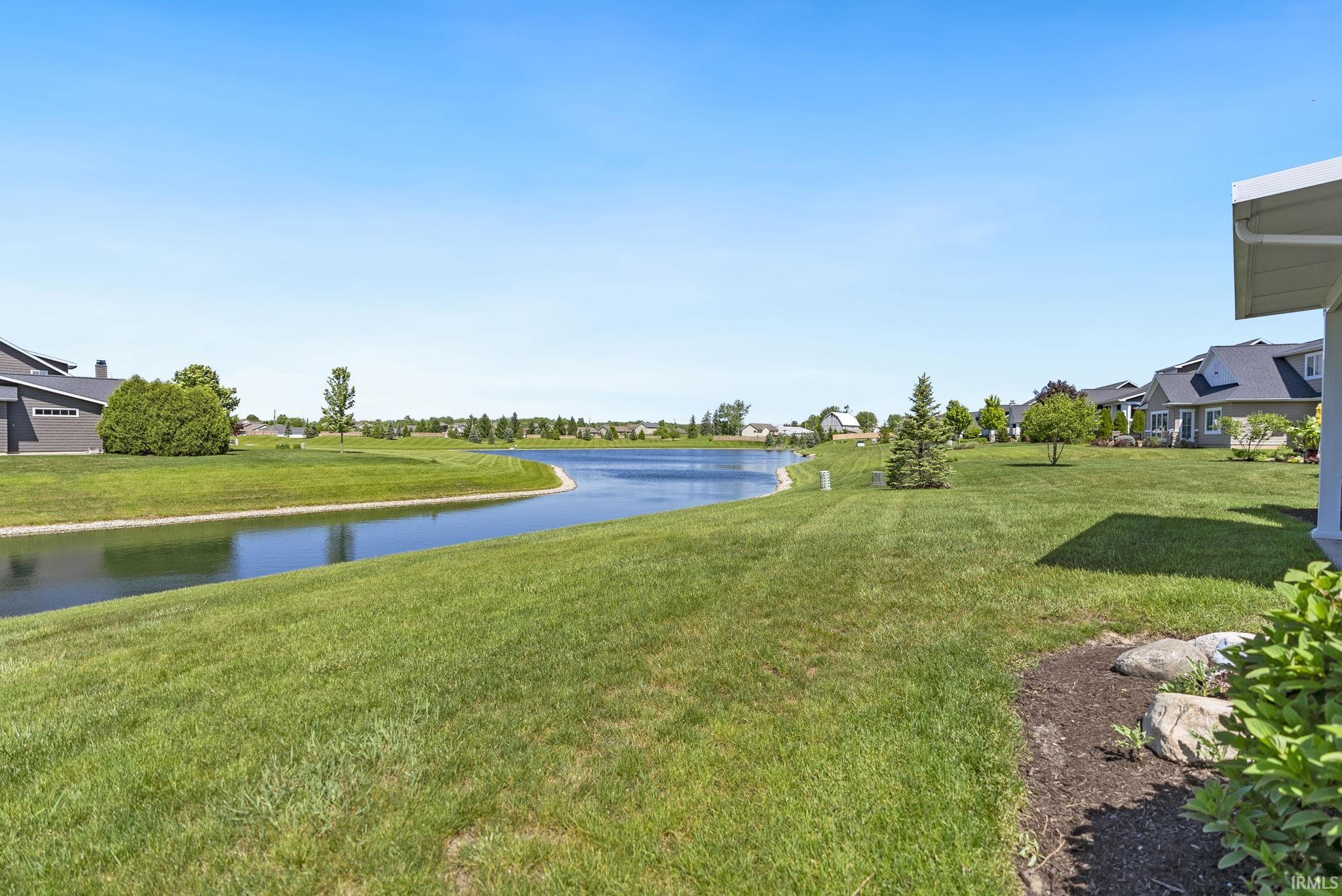 Expansive green lawn bordering a reflective waterway