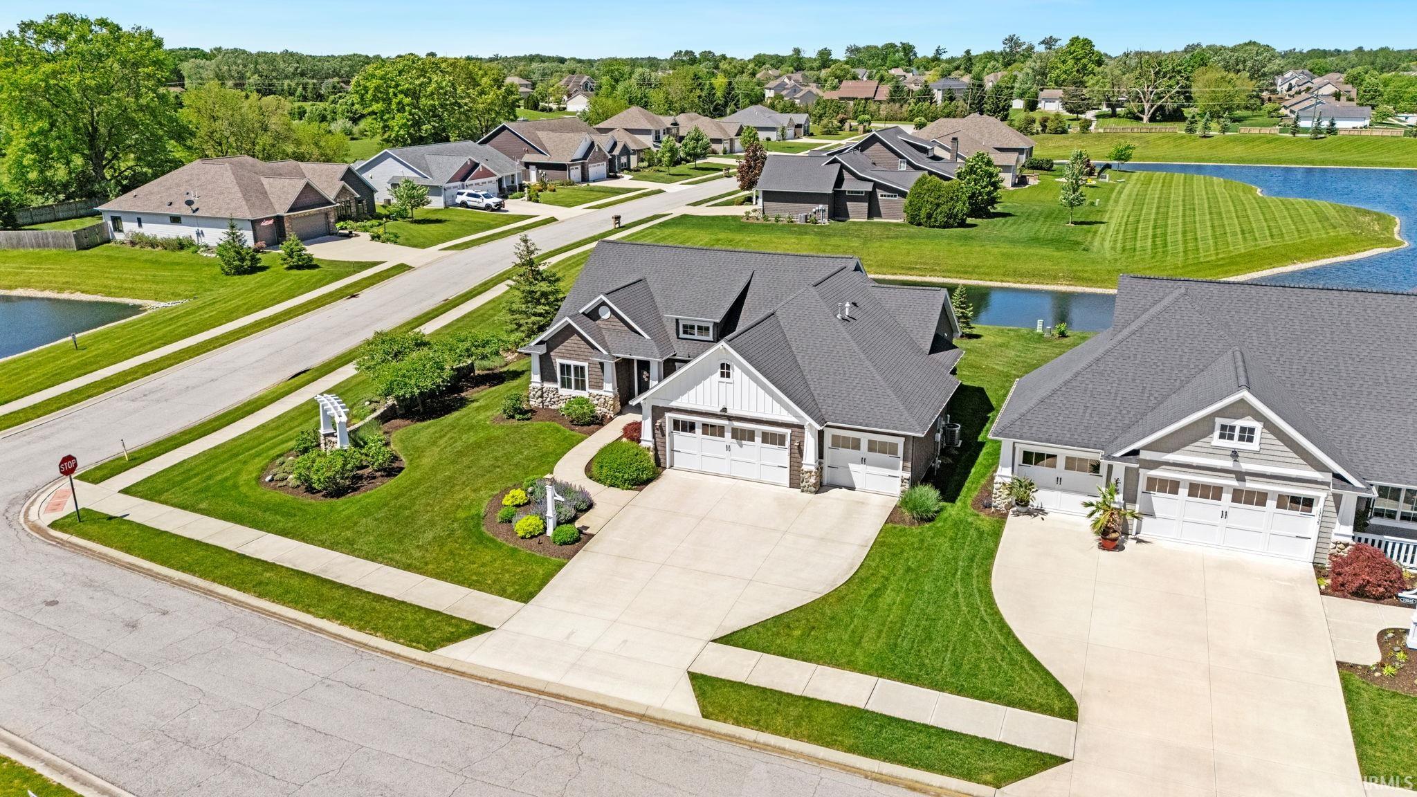 Two-story residence featuring a two-car garage, dark gray shingle roof, and a combination of horizontal siding and vertical board and batten accents