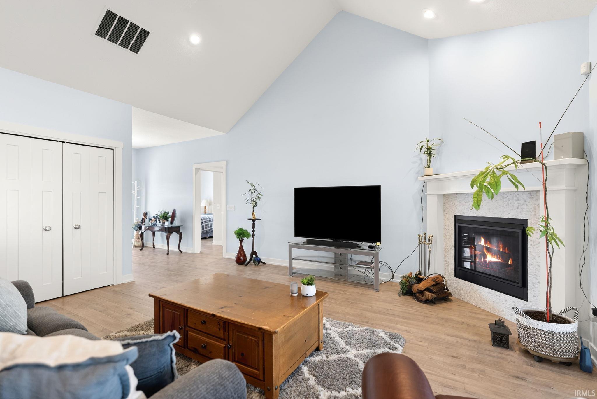 Spacious interior featuring a vaulted ceiling, recessed lighting, and wood-finish flooring