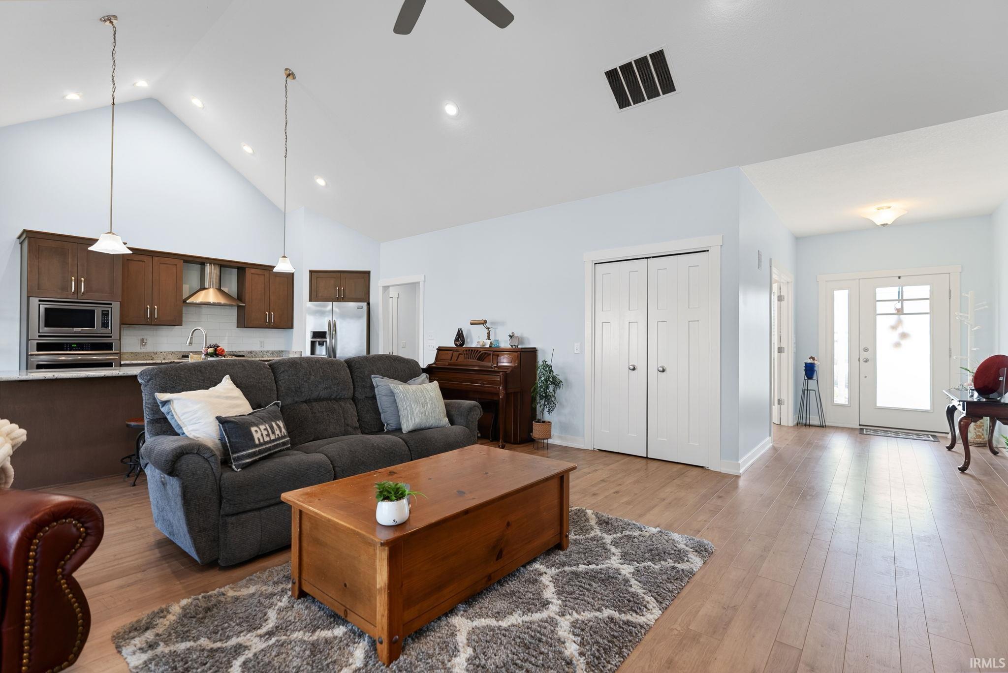 Open-concept living space featuring a vaulted ceiling with recessed lighting and a ceiling fan