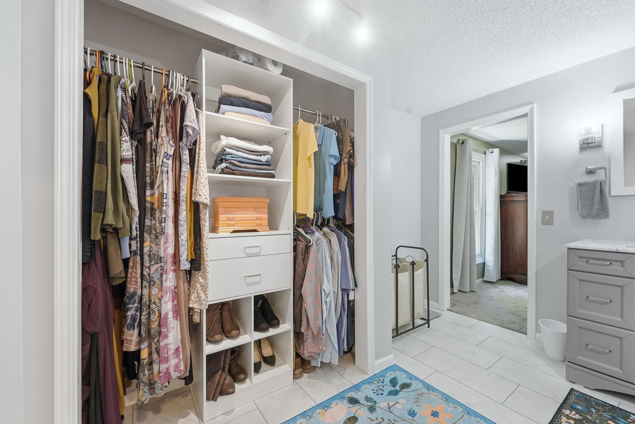 Custom closet organization system with integrated shelving, drawers, and hanging rods