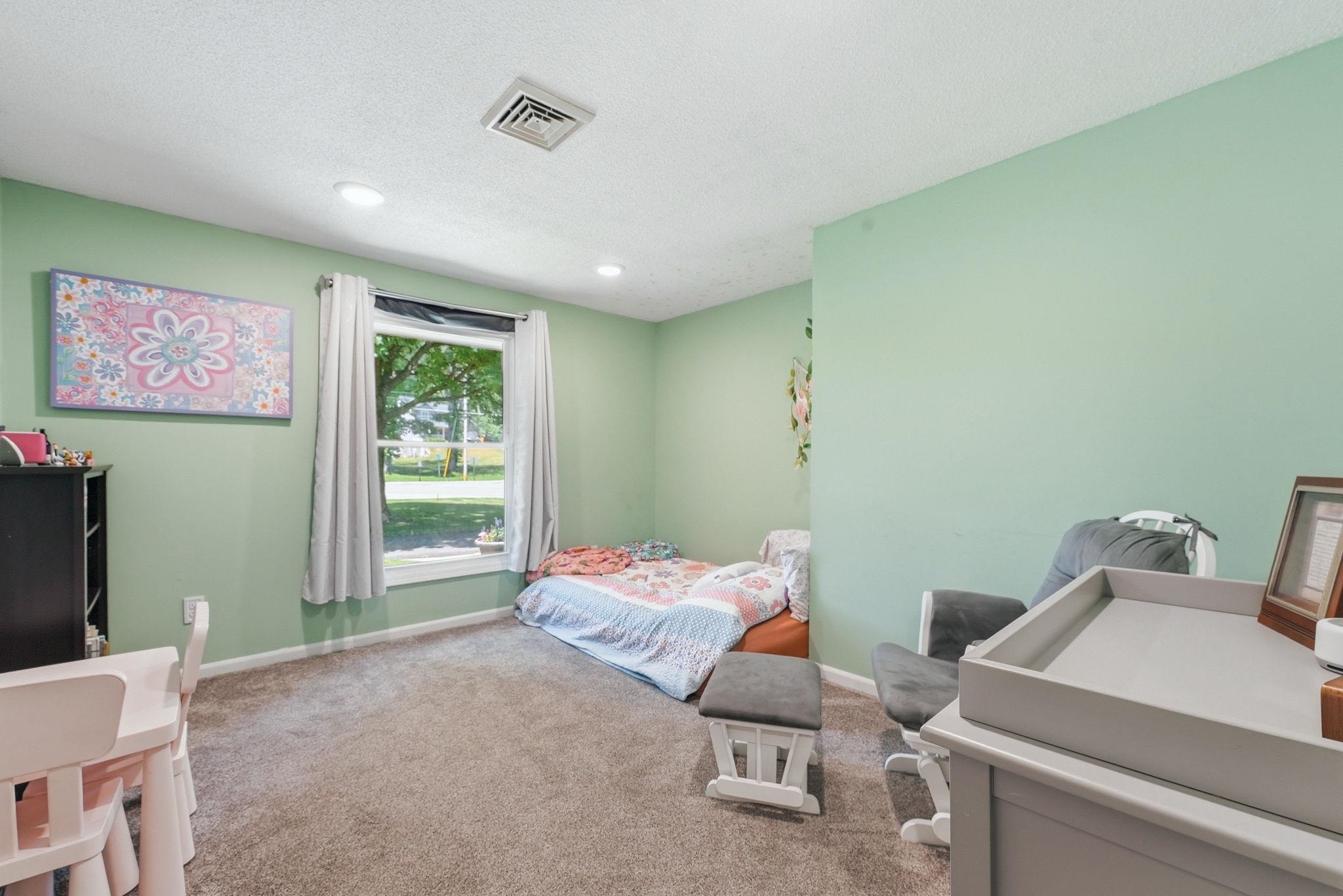 Soft green walls complement the neutral carpeting in this room