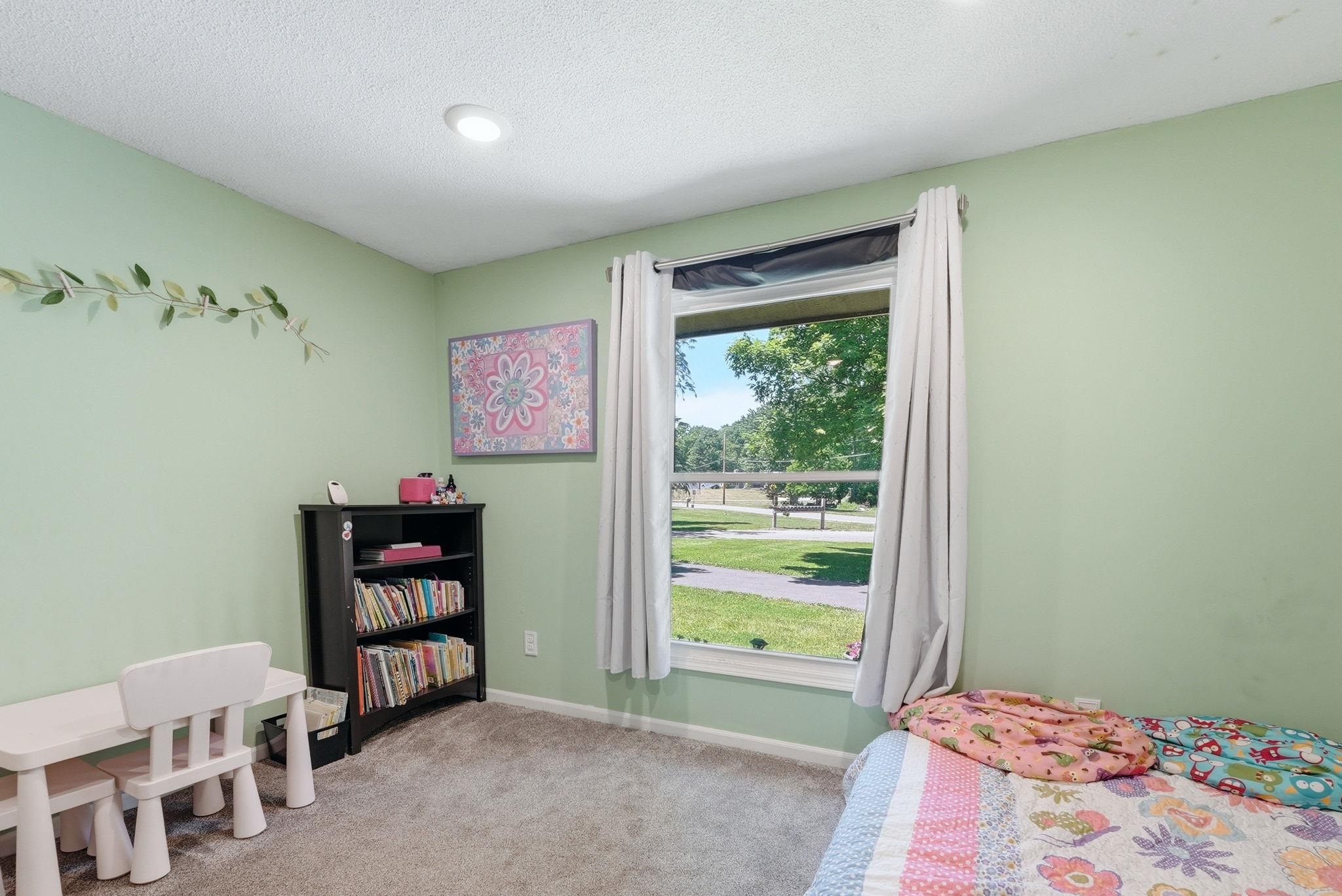 Carpeted room featuring a large window, recessed lighting, and light green painted walls