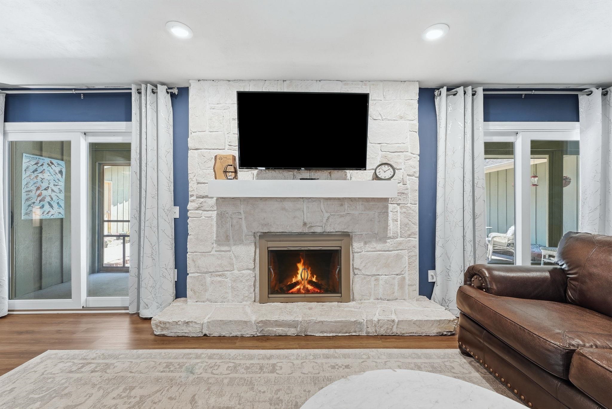 Stone-clad fireplace with hearth, integrated firebox, and mantel