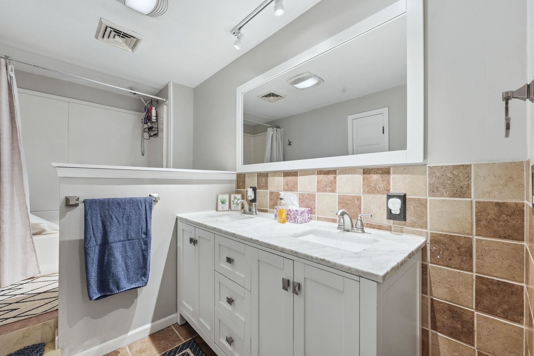 Dual sink vanity with white cabinetry and a light-toned countertop