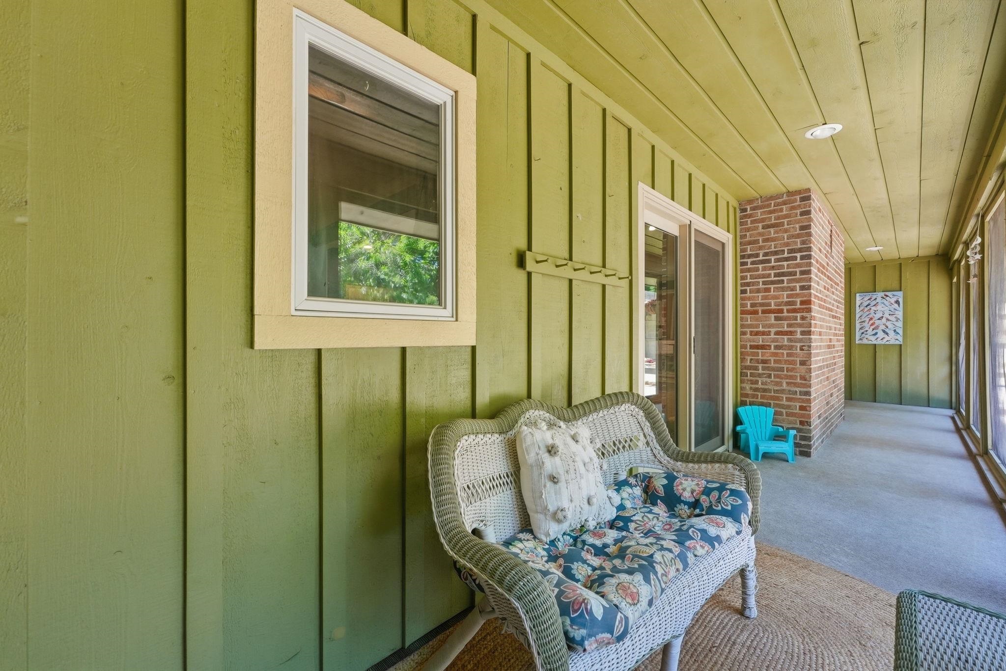 Covered porch featuring vertical wood paneling, a tongue and groove ceiling, recessed lighting, and brick accents