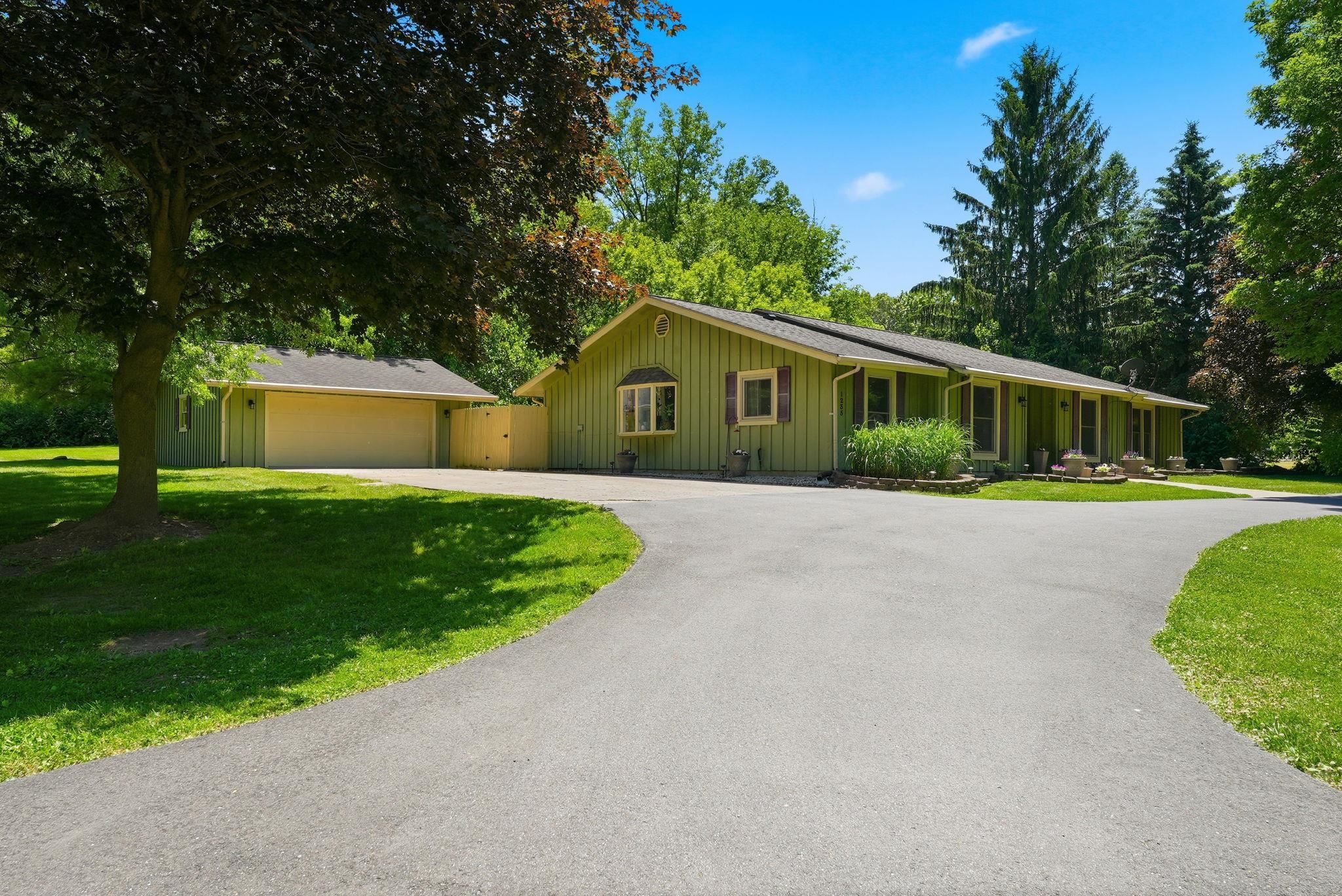 Ranch-style residence featuring a split driveway, a two-car garage, and a bay window