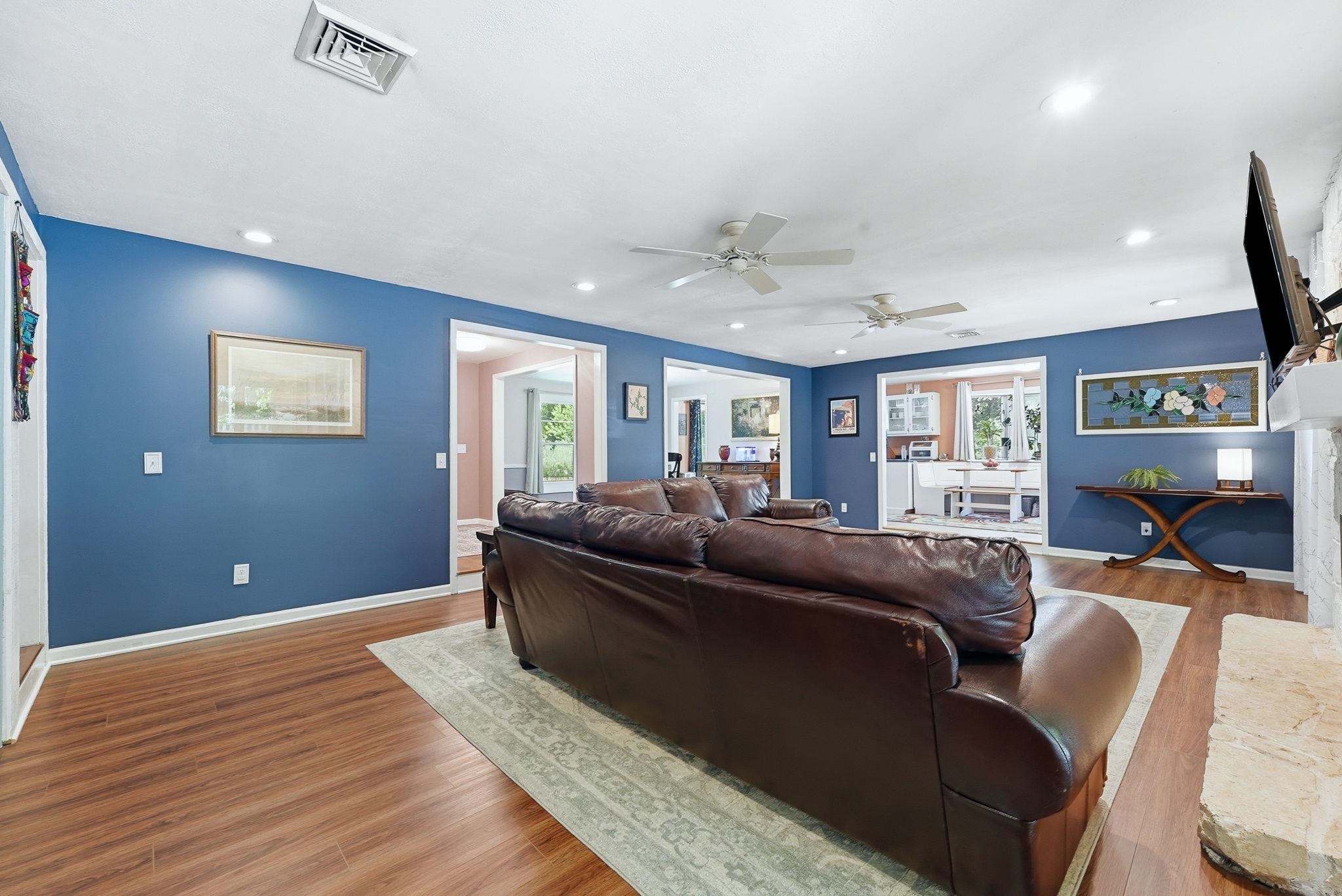 Spacious interior featuring wood-finish flooring, recessed lighting, and ceiling fans
