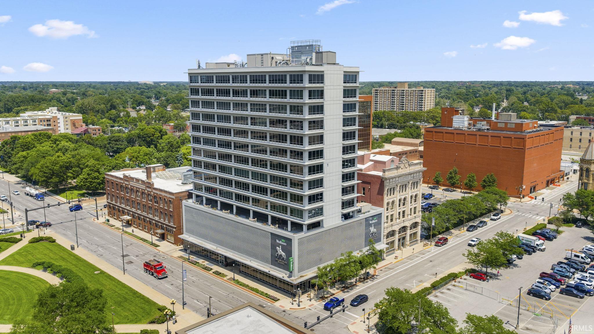 Modern high-rise building with extensive window lines, featuring a multi-story base and a prominent corner location