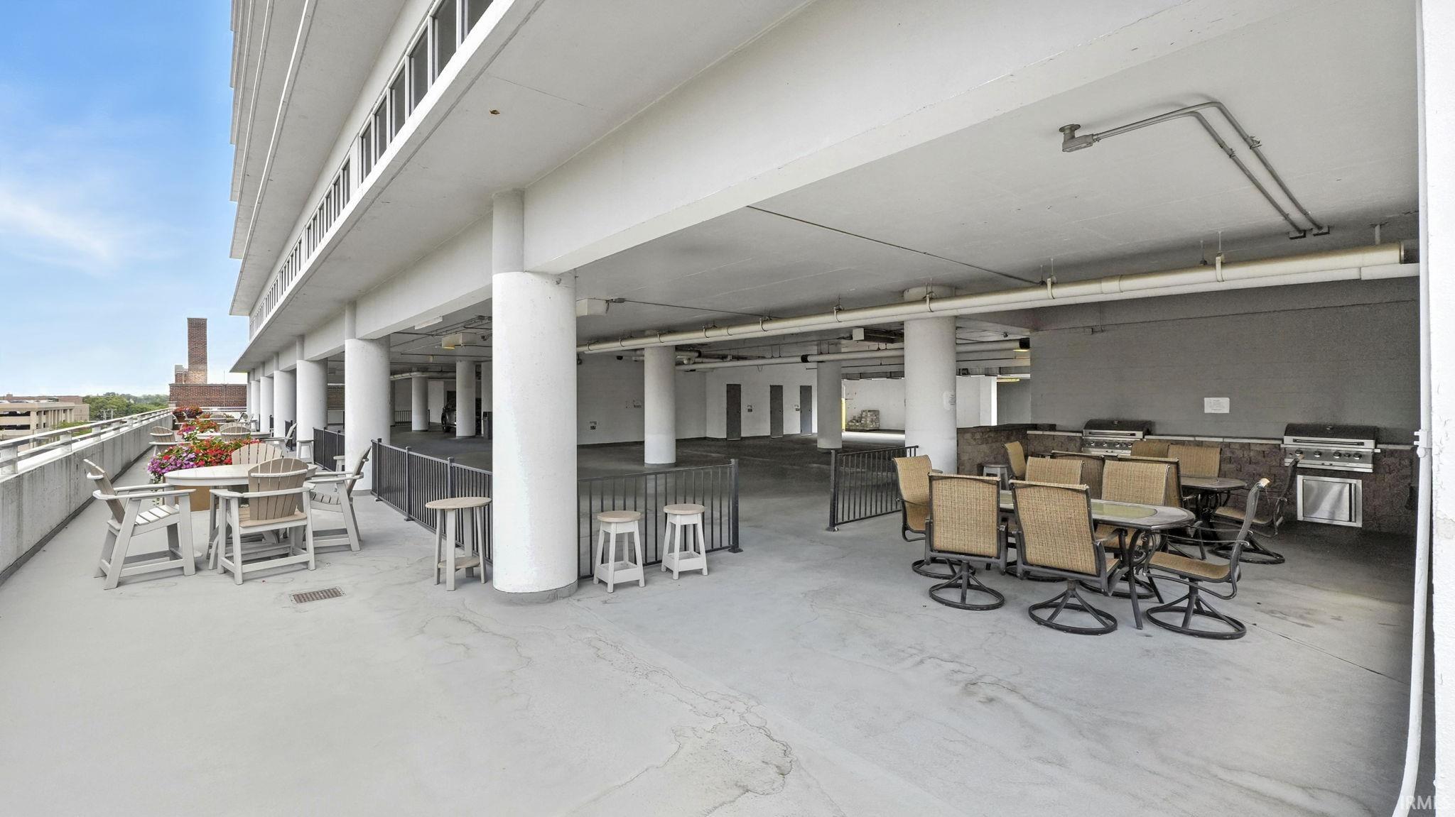 Spacious rooftop patio featuring multiple seating areas and built-in grilling stations