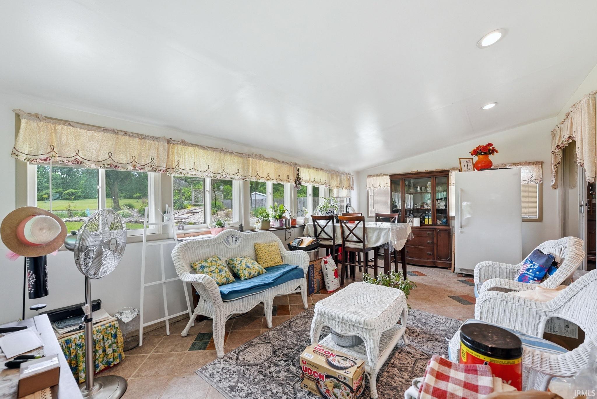 Sunroom featuring multiple windows, recessed lighting, and tile flooring