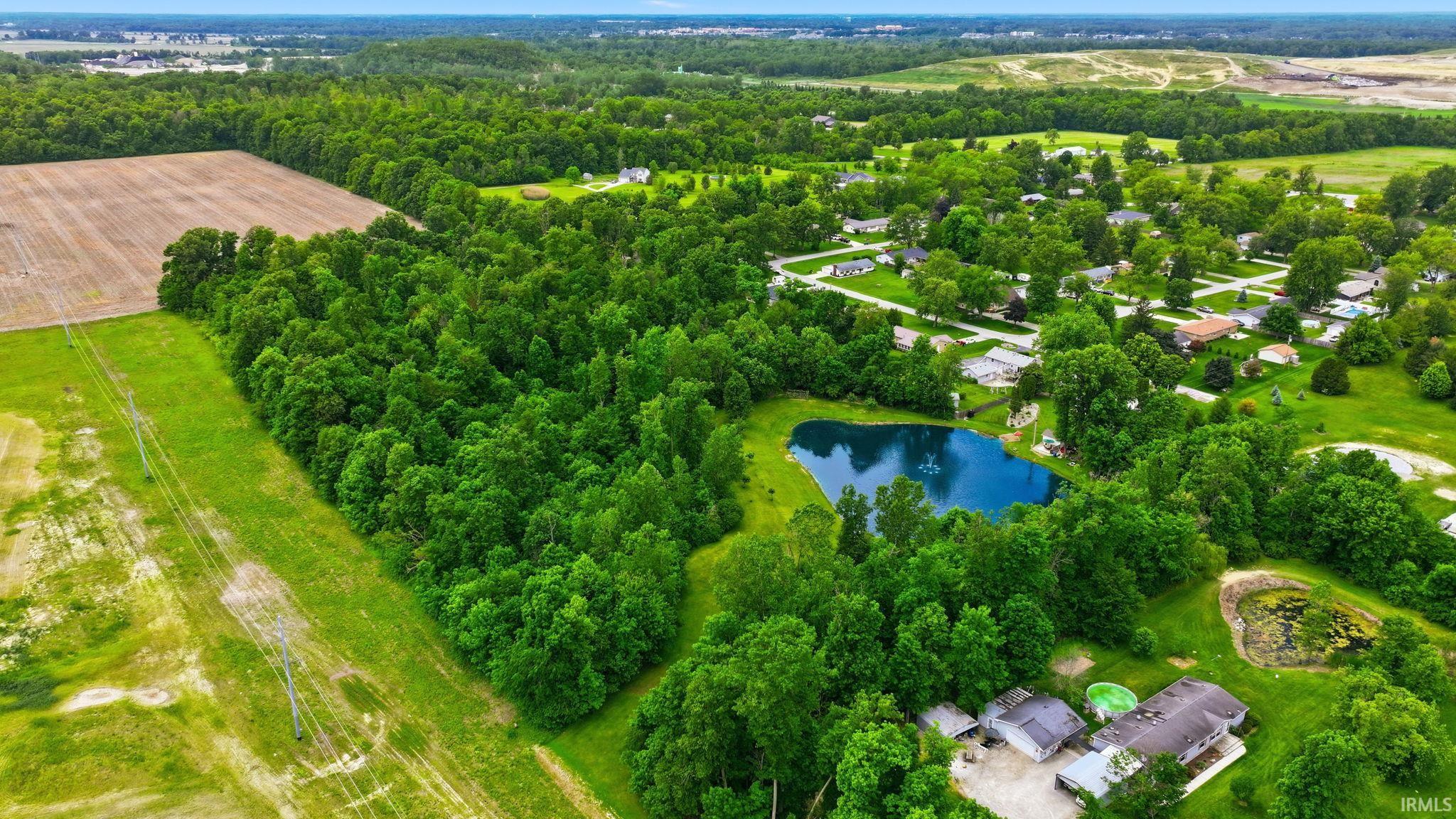 Expansive wooded acreage featuring a private pond and surrounding green space