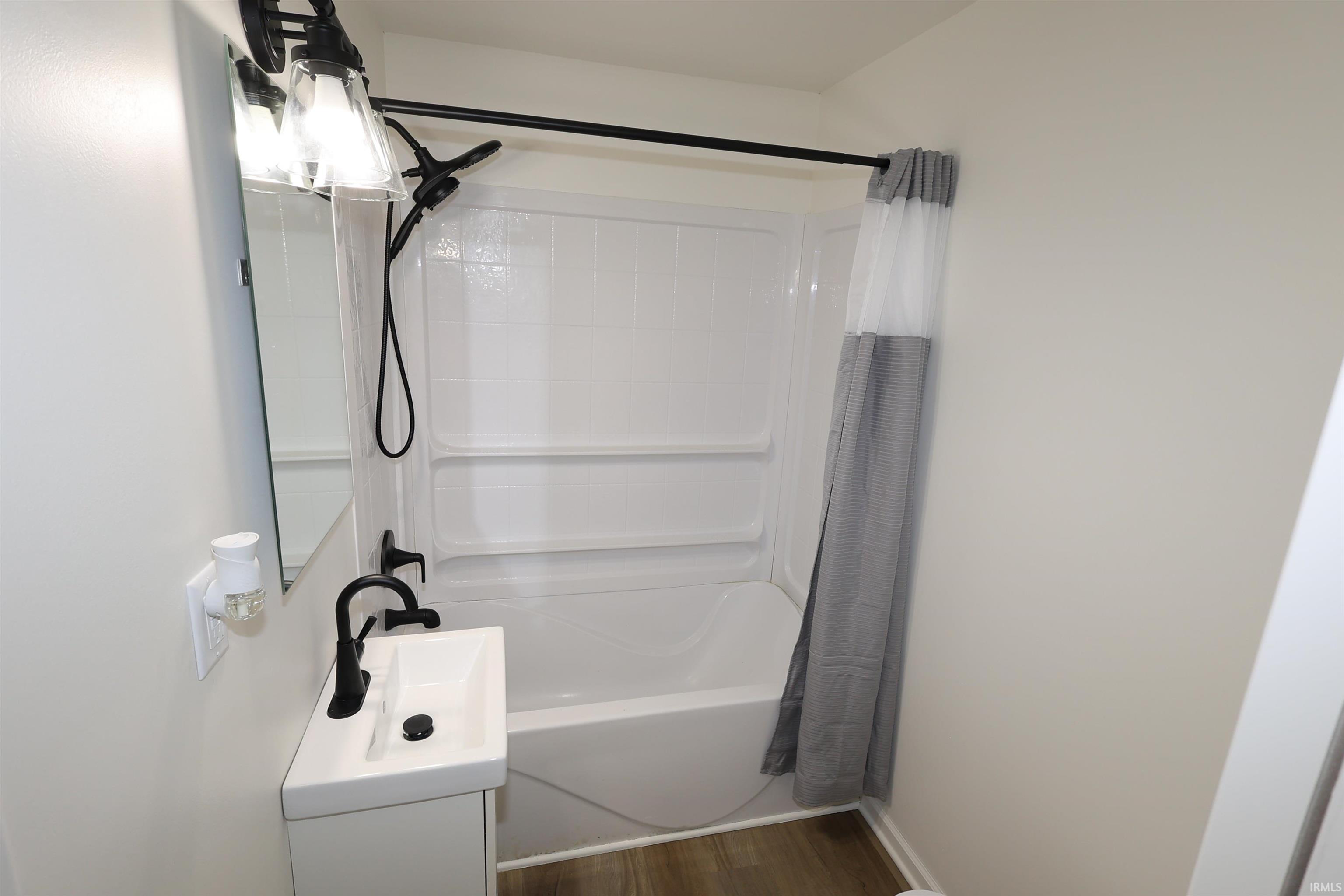 Bathroom featuring a white tub/shower combination with a black shower head and faucet
