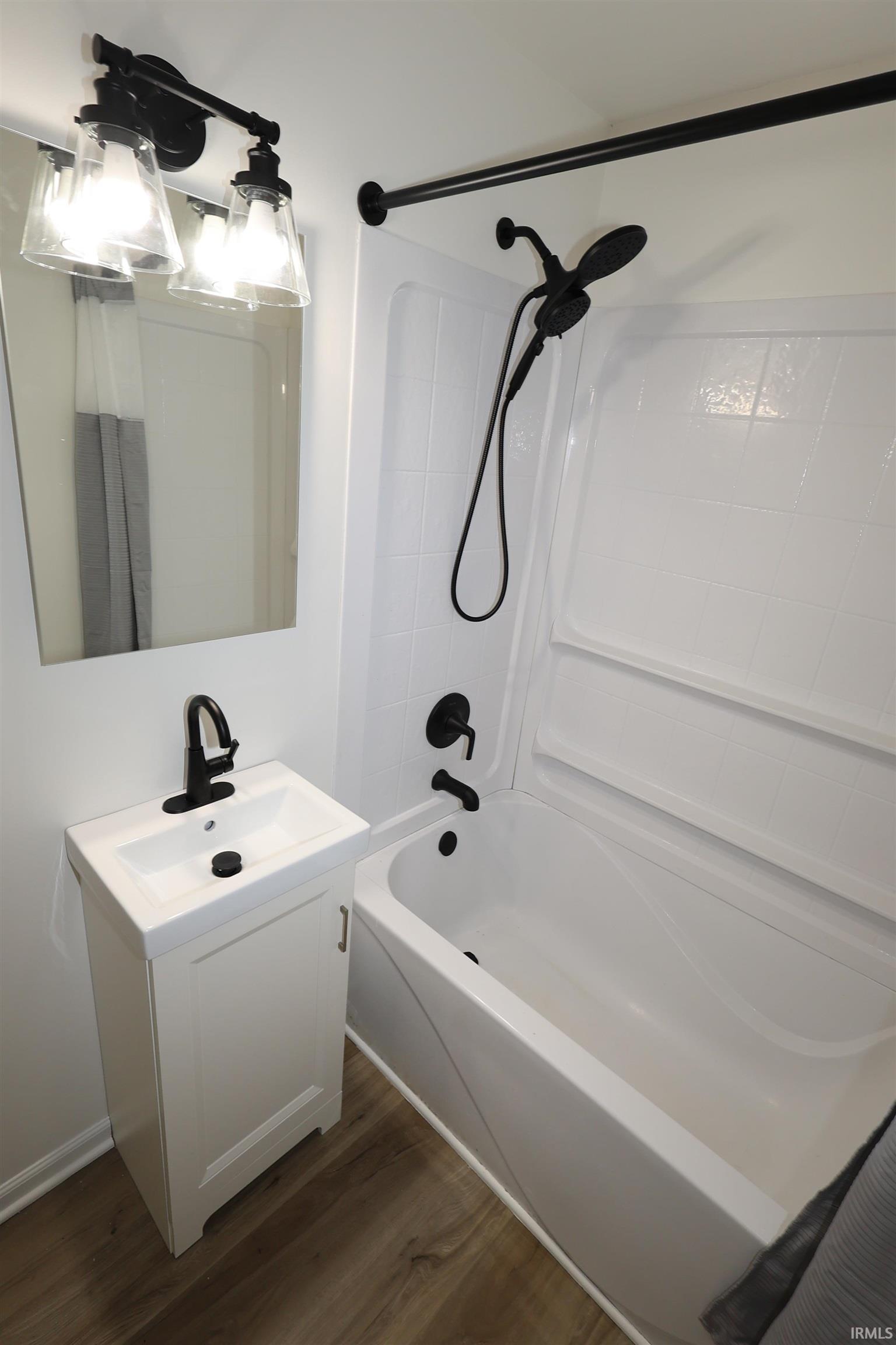 Contemporary bathroom featuring a white vanity with integrated sink, black matte faucet, and matching black matte shower fixtures