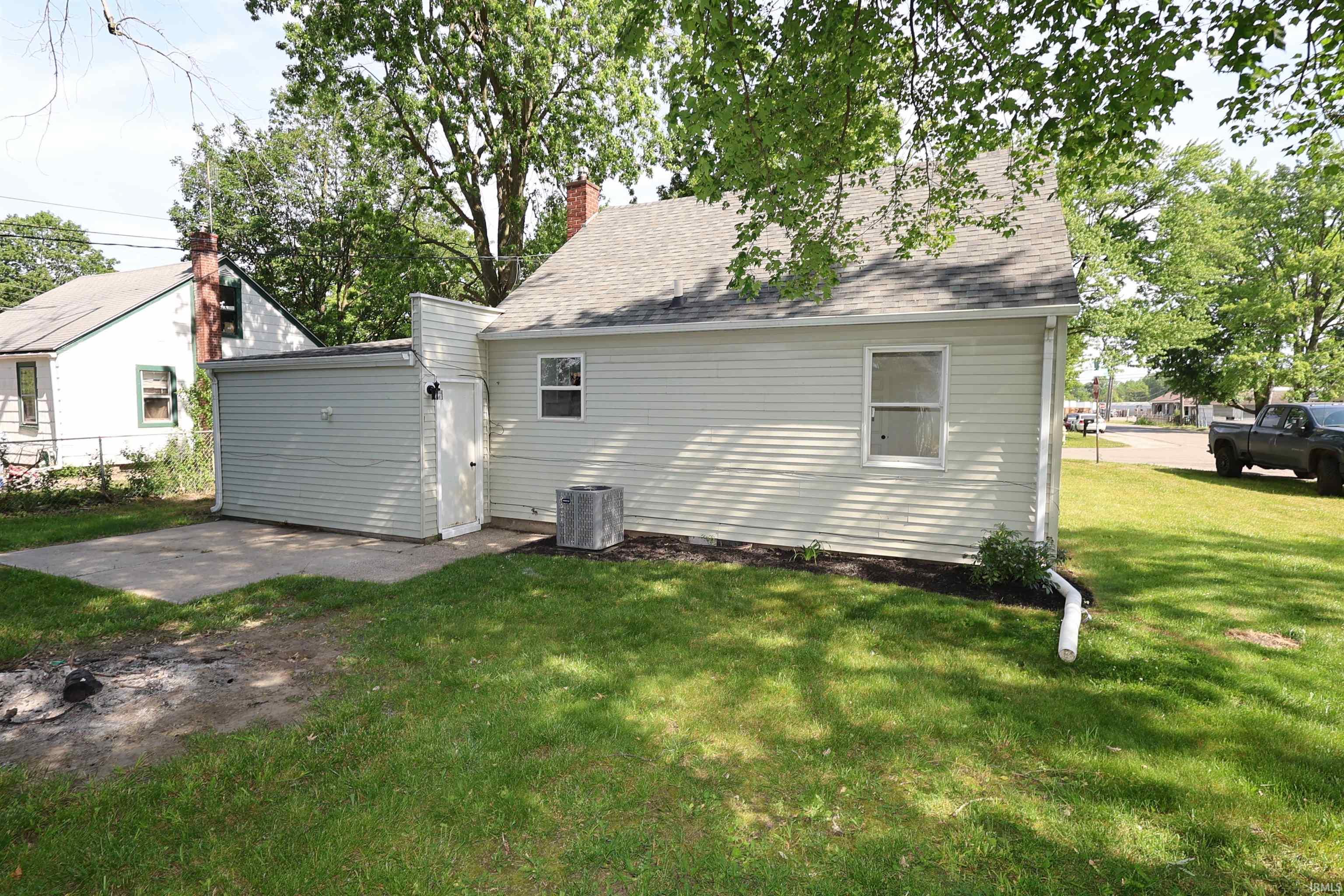 Rear exterior with light-colored siding and a gray shingle roof