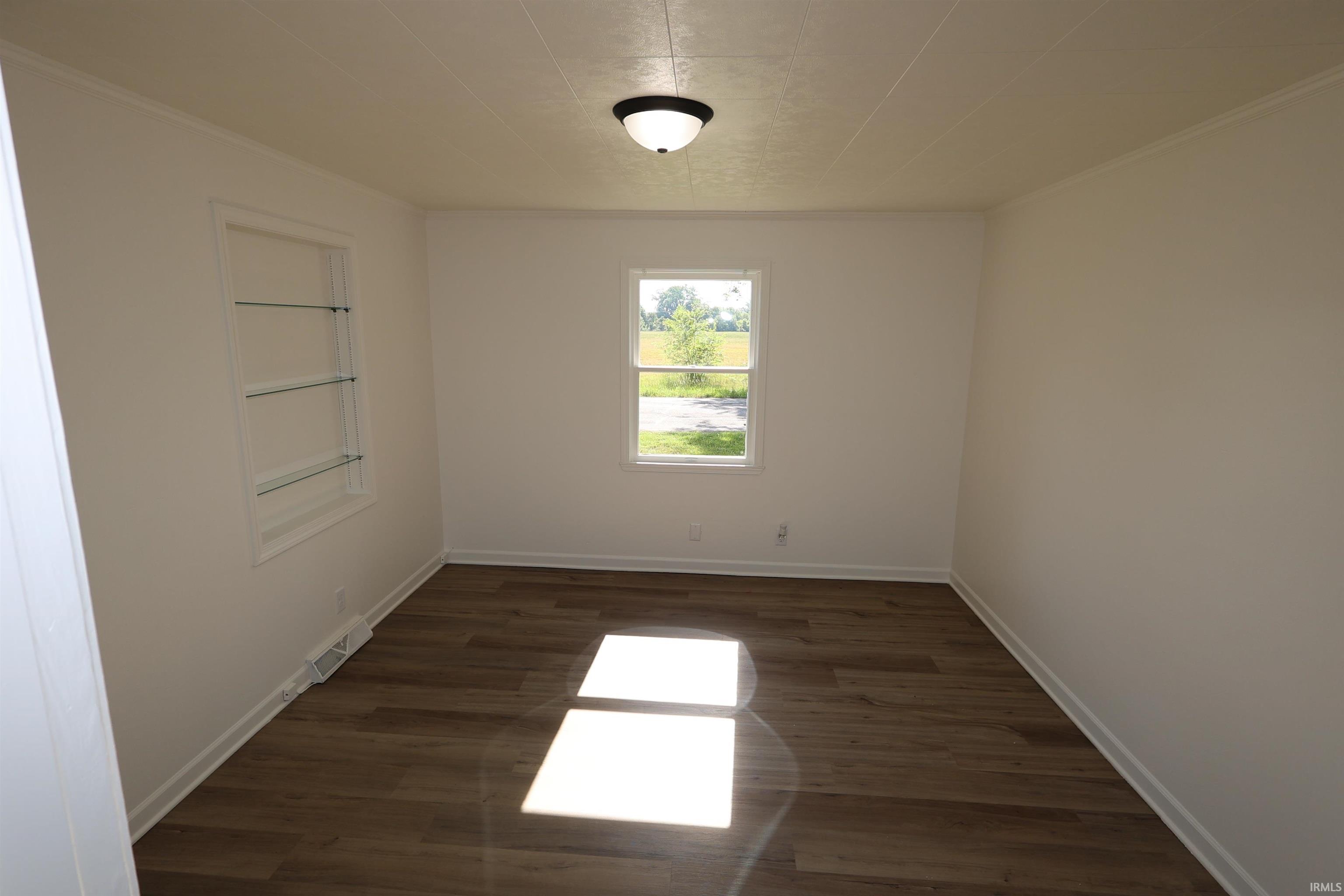 Room featuring wood-finish flooring, white painted walls, and white trim