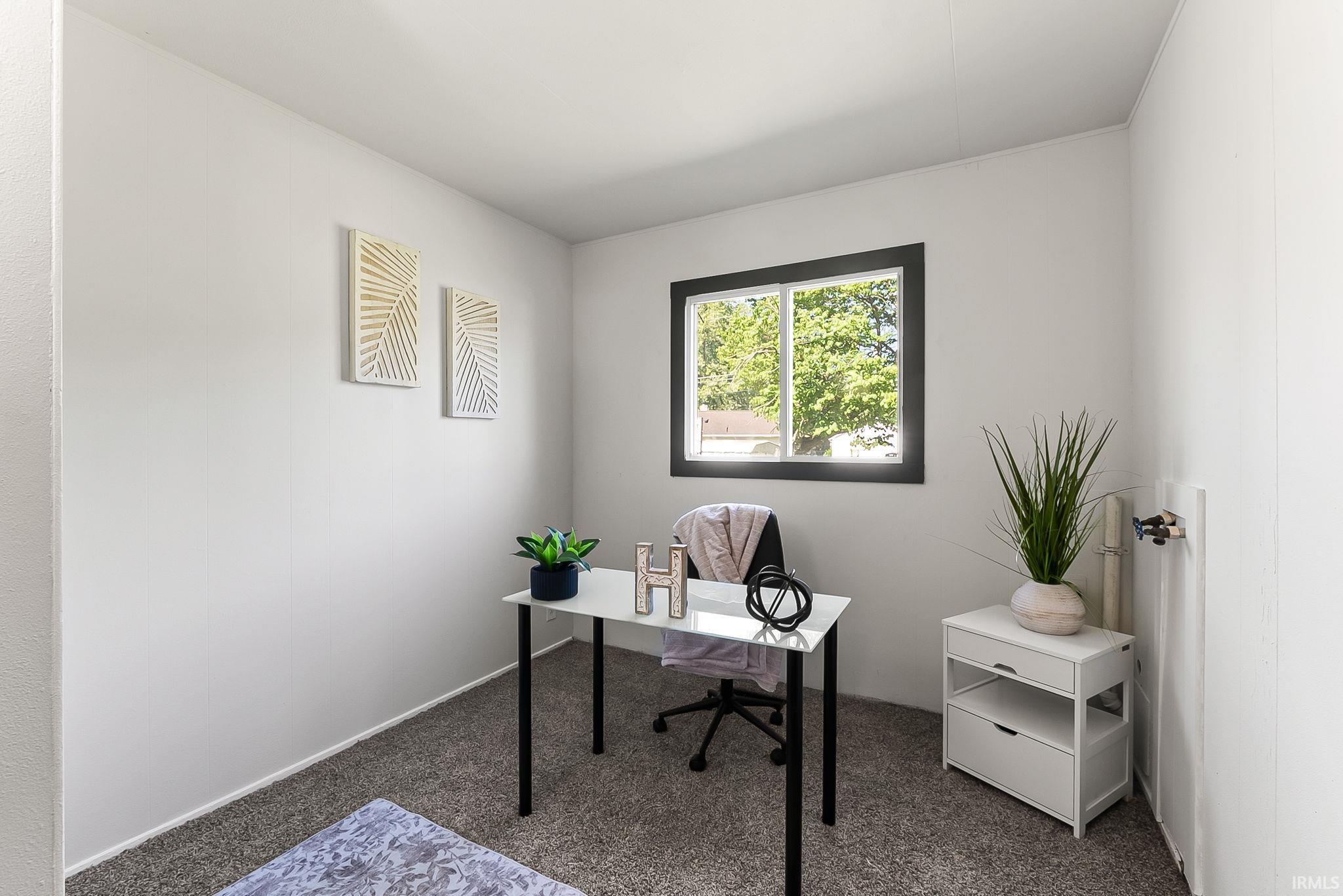 Room featuring neutral wall paint, a dark-trimmed window, gray carpet flooring, and white baseboards