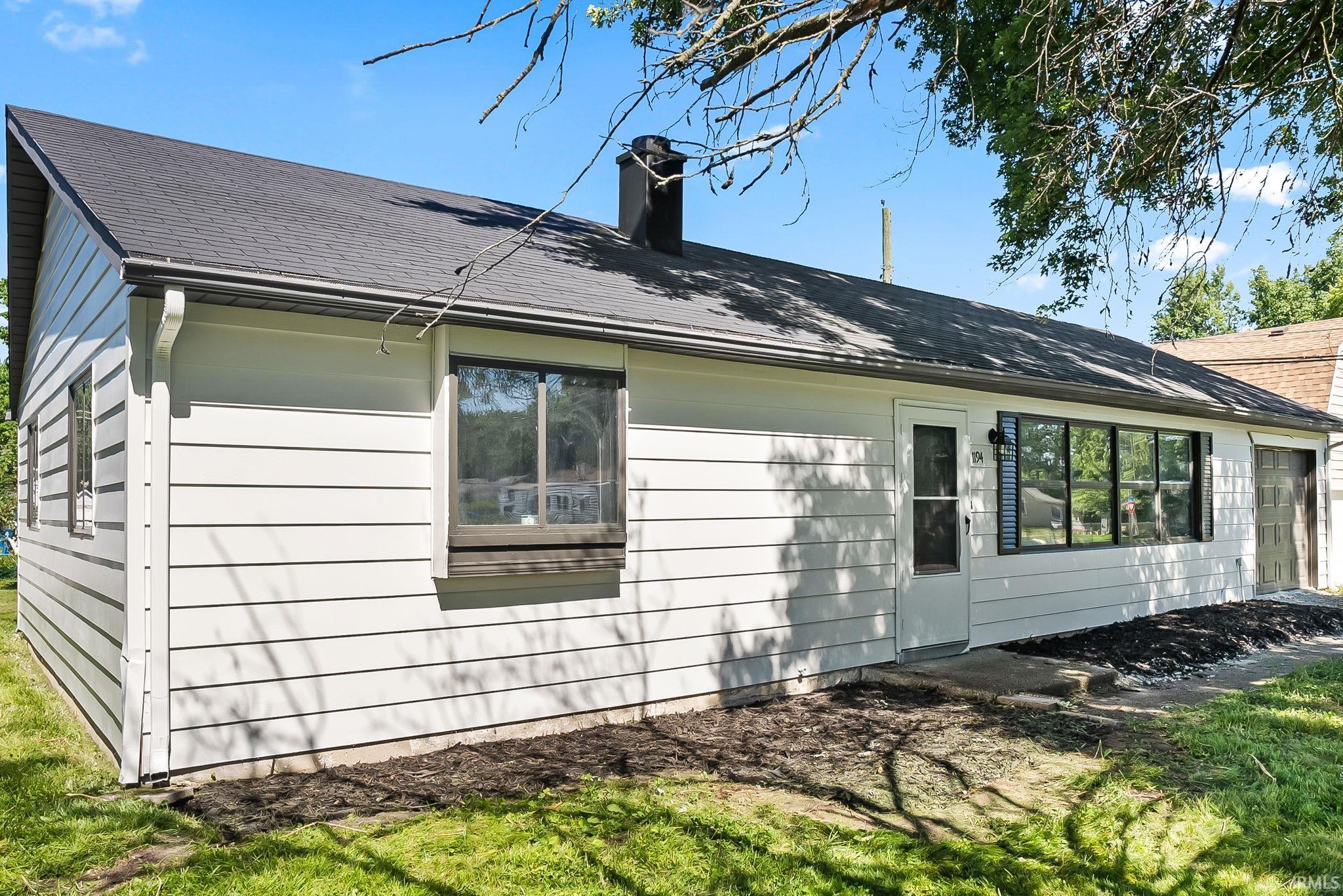 White horizontal siding exterior with a dark shingle roof