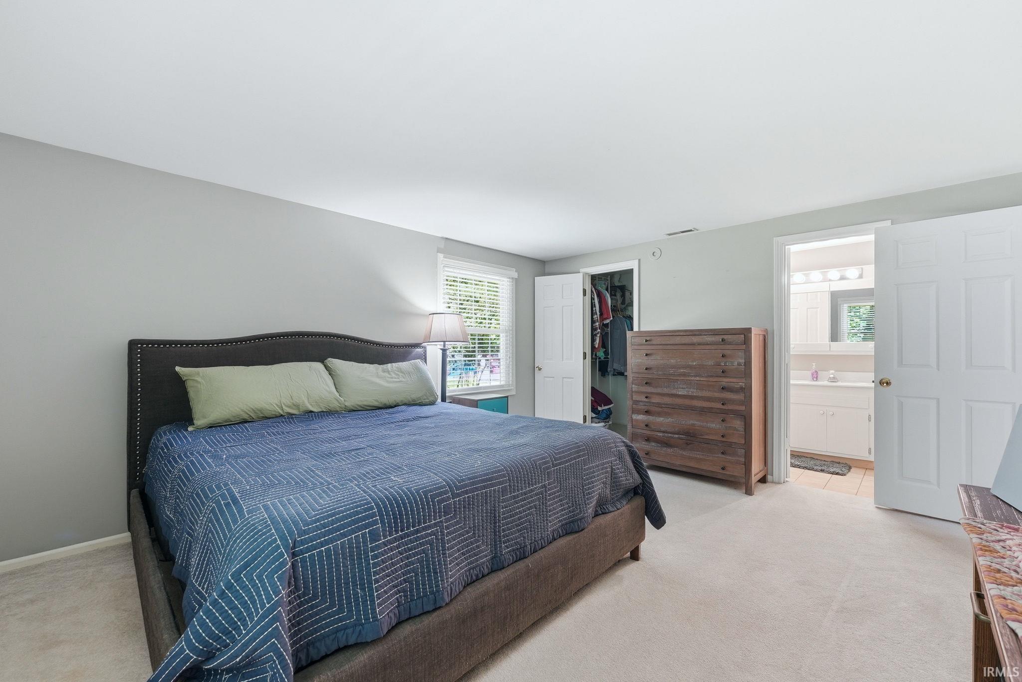 Carpeted sleeping area with light gray walls and white trim