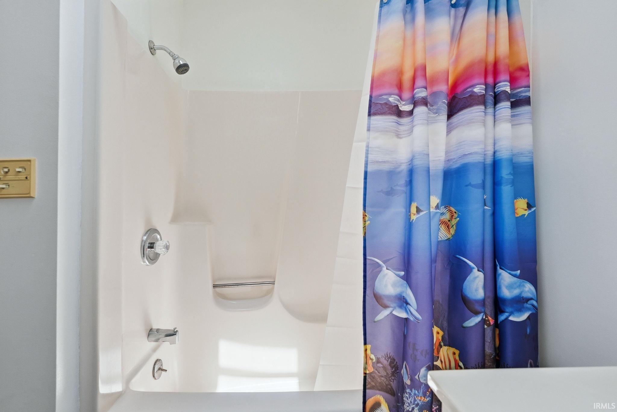 White tub and shower combination with chrome fixtures