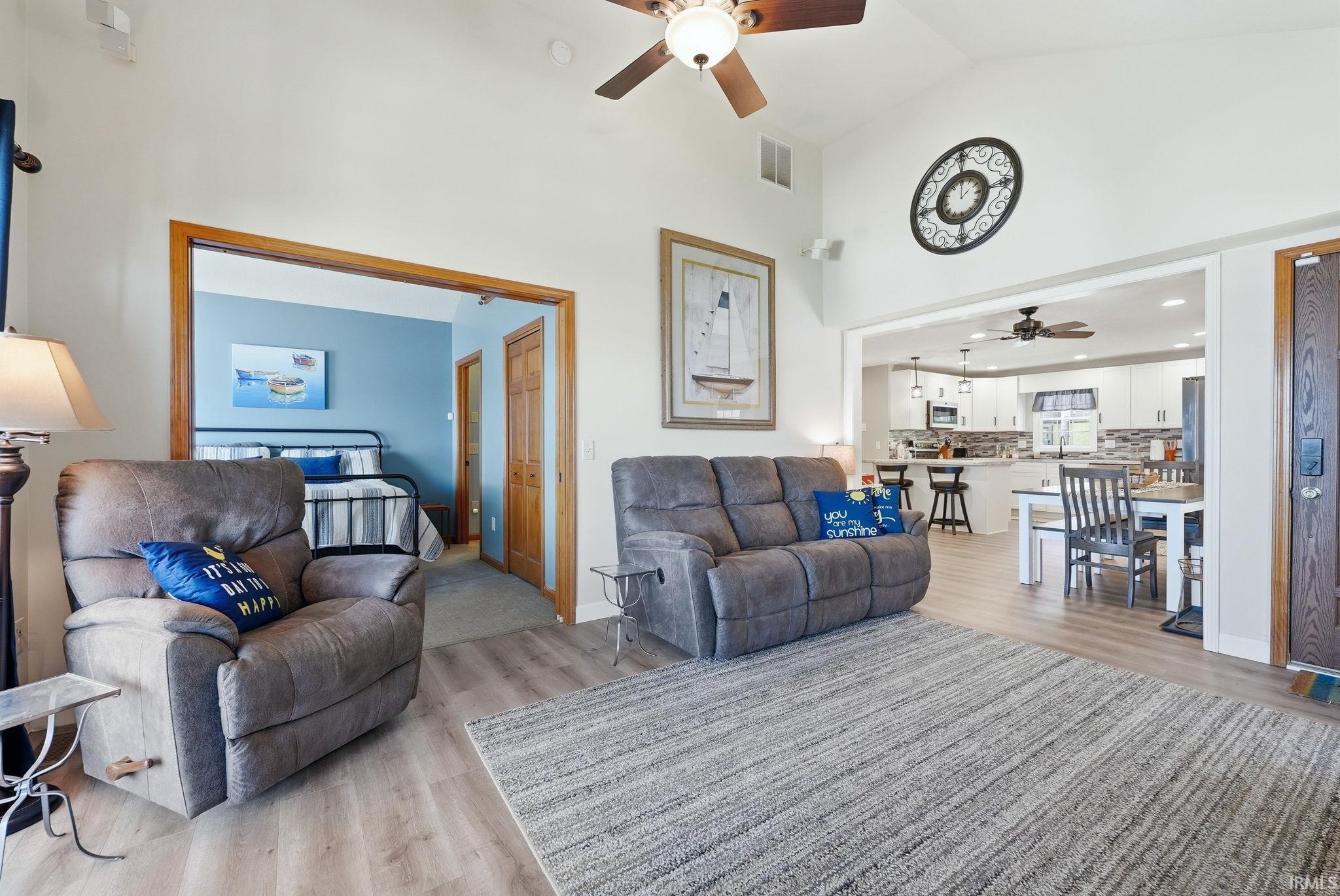 Living area featuring vaulted ceilings, wood-finish flooring, and an open-concept layout